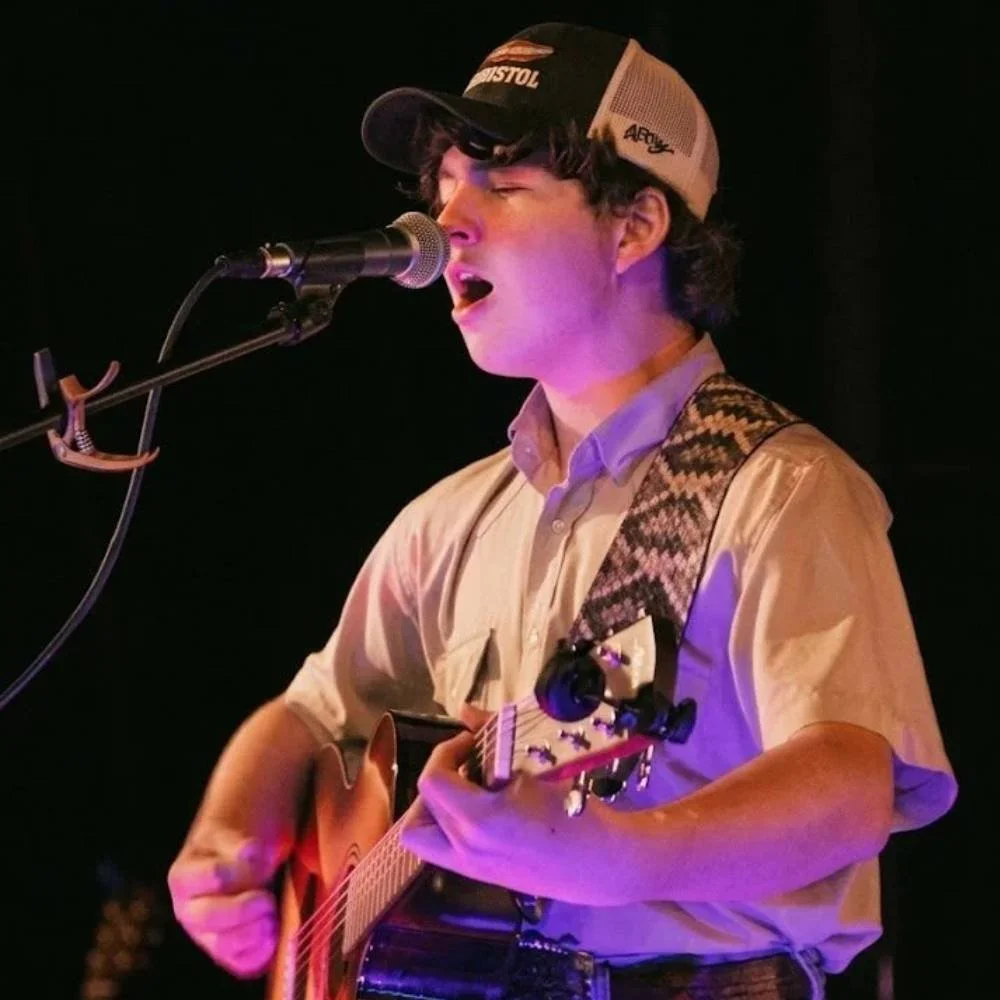 Live acoustic musician performing on stage during a restaurant event.