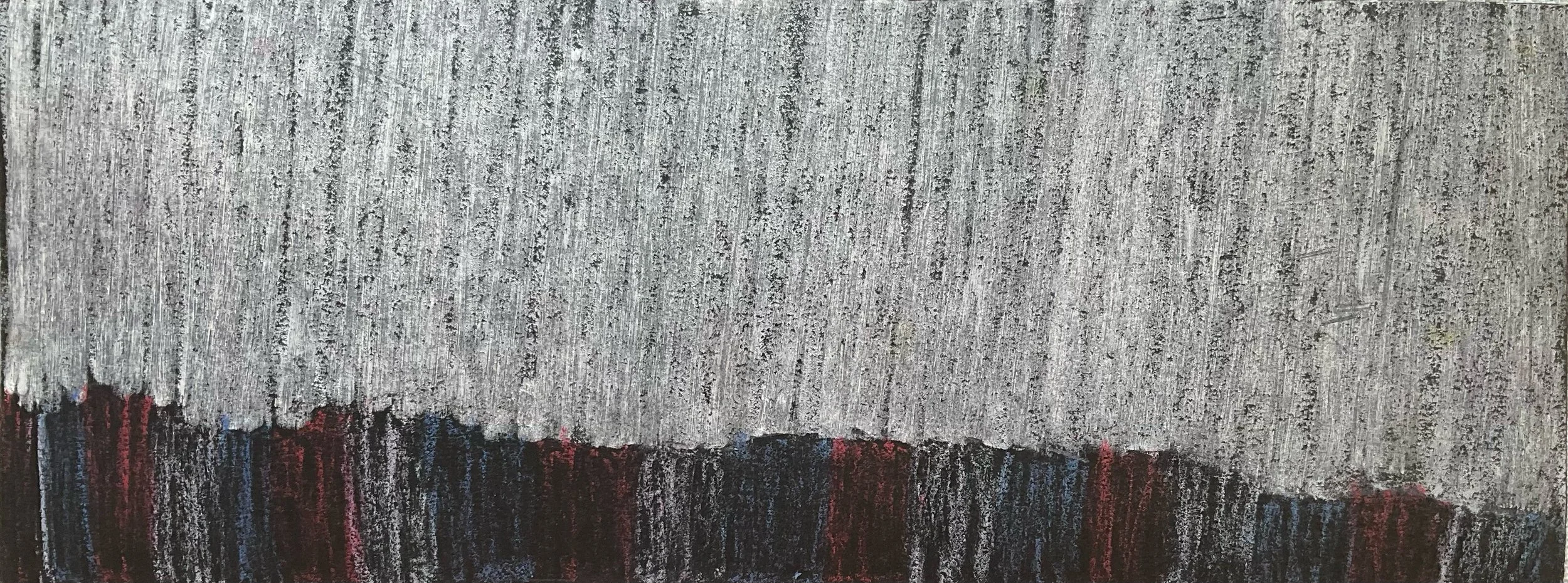 Close-up of a textured carpet with a pattern of mostly gray with a dark and colorful border at the bottom.