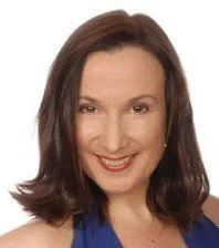 Portrait of a smiling woman with shoulder-length dark hair, wearing a blue top.