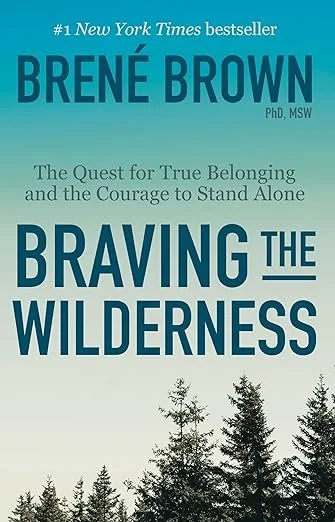 Book cover for 'Braving the Wilderness' by Brené Brown, featuring a light blue background and black silhouettes of trees at the bottom.