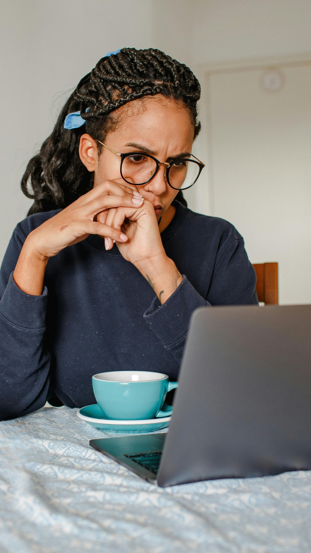 A woman pausing in front of her laptop while working from home.