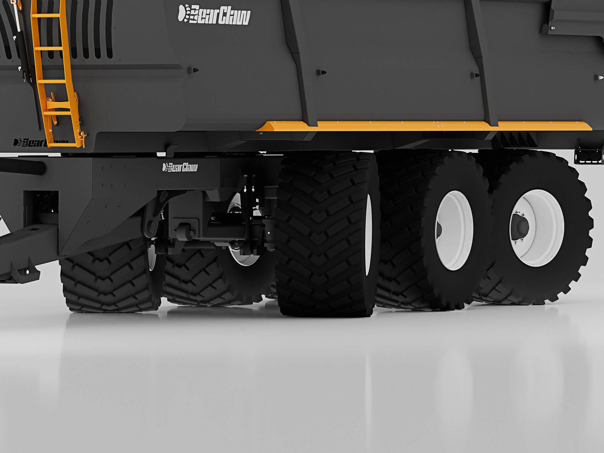 Close-up of a large heavy-duty truck's rear wheels and chassis, with a gray body and yellow accents on part of the truck's structure.