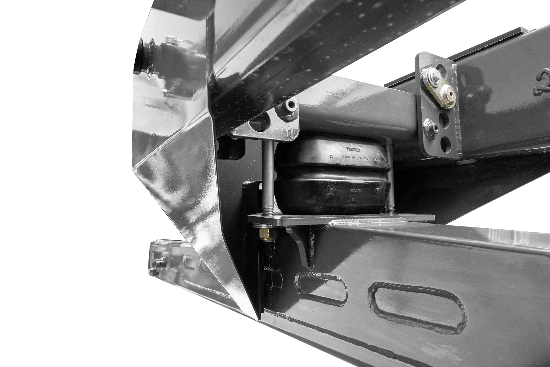 Close-up view of a mechanical parts assembly including a shock absorber, metal brackets, bolts, and a black rubber component, likely part of a vehicle or machinery.