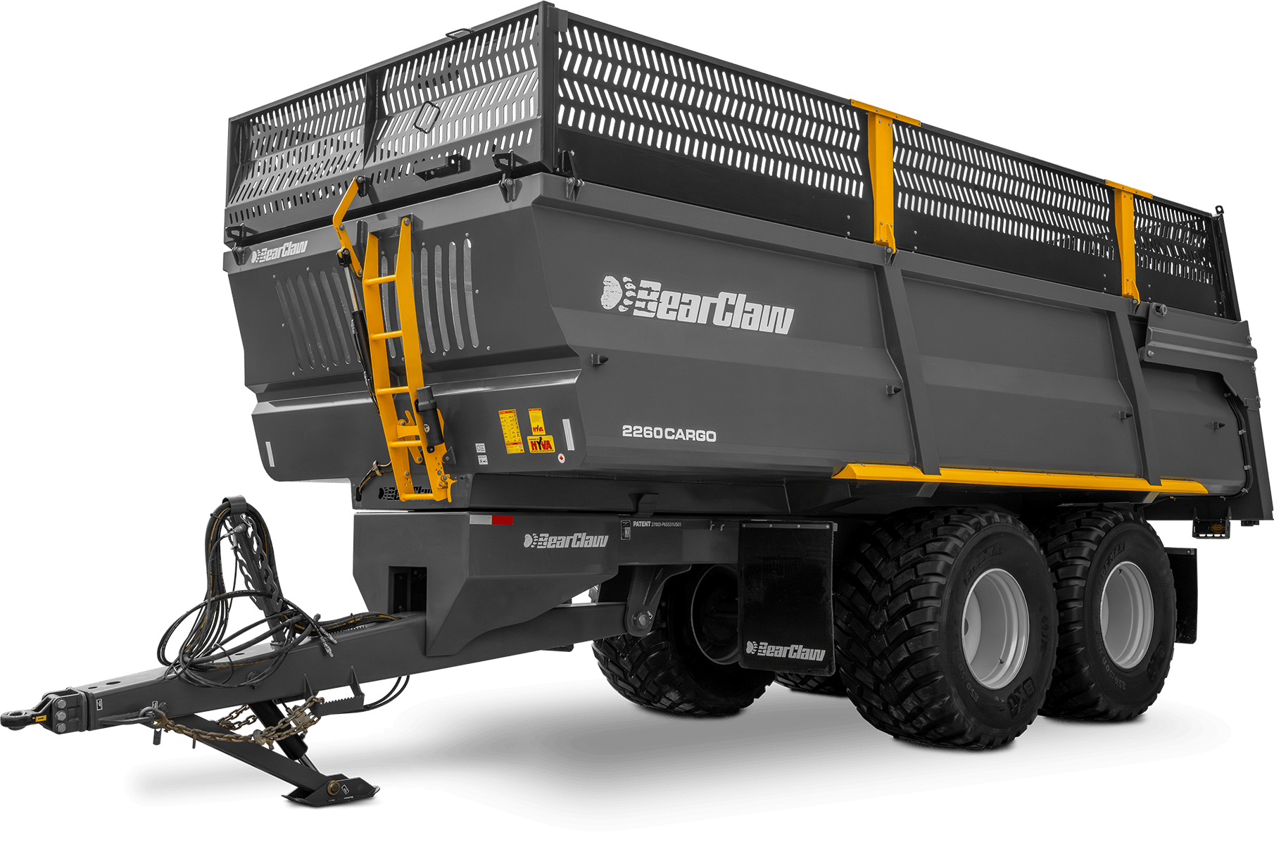 A gray BearClaw 2260 Cargo agricultural wagon with large rugged tires and yellow safety bars, featuring the BearClaw logo and various safety labels, equipped with hydraulic and electrical hookup cables at the front.