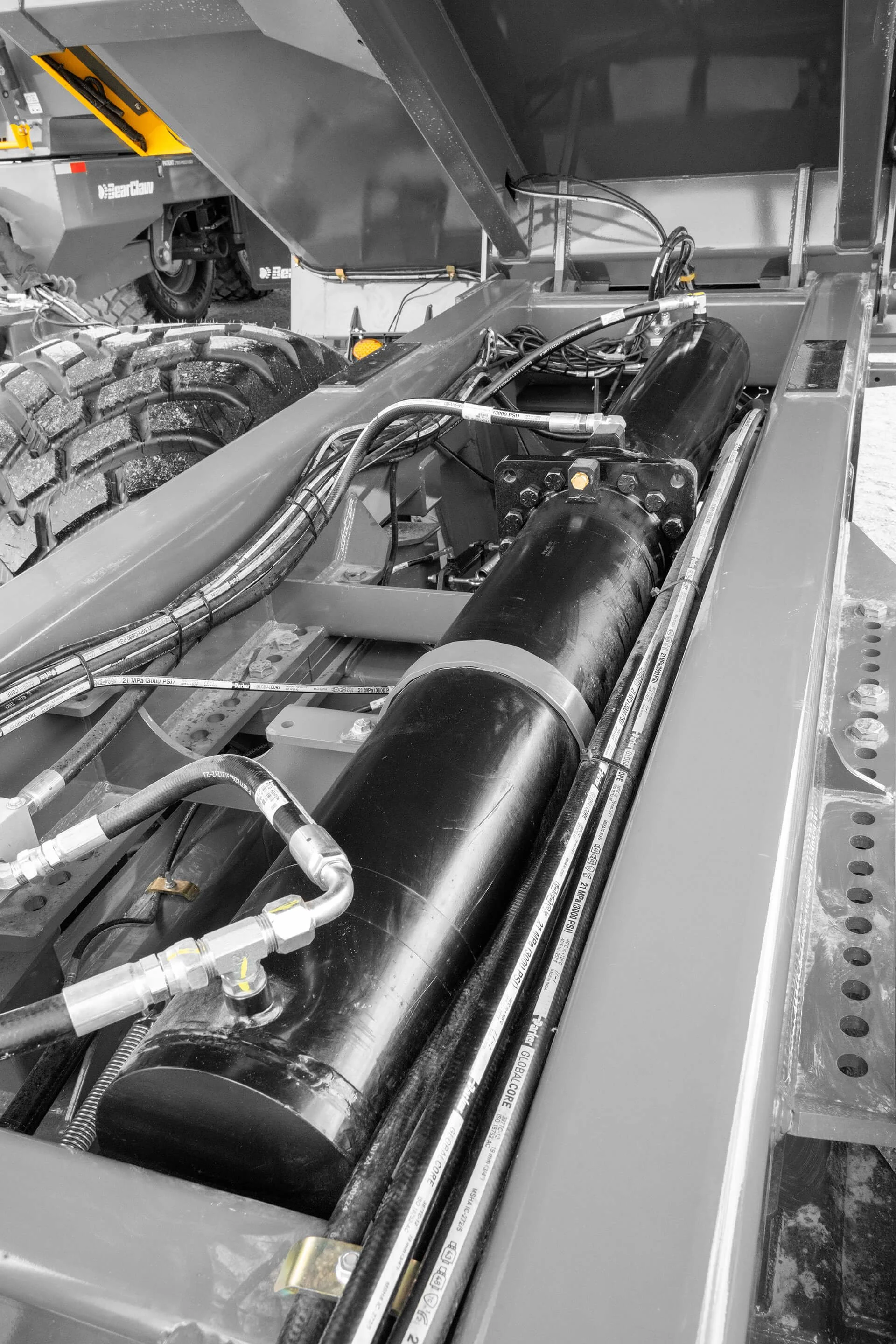 Close-up of industrial machinery with hydraulic hoses, pipes, and metal components, possibly part of heavy equipment or a hydraulic system.