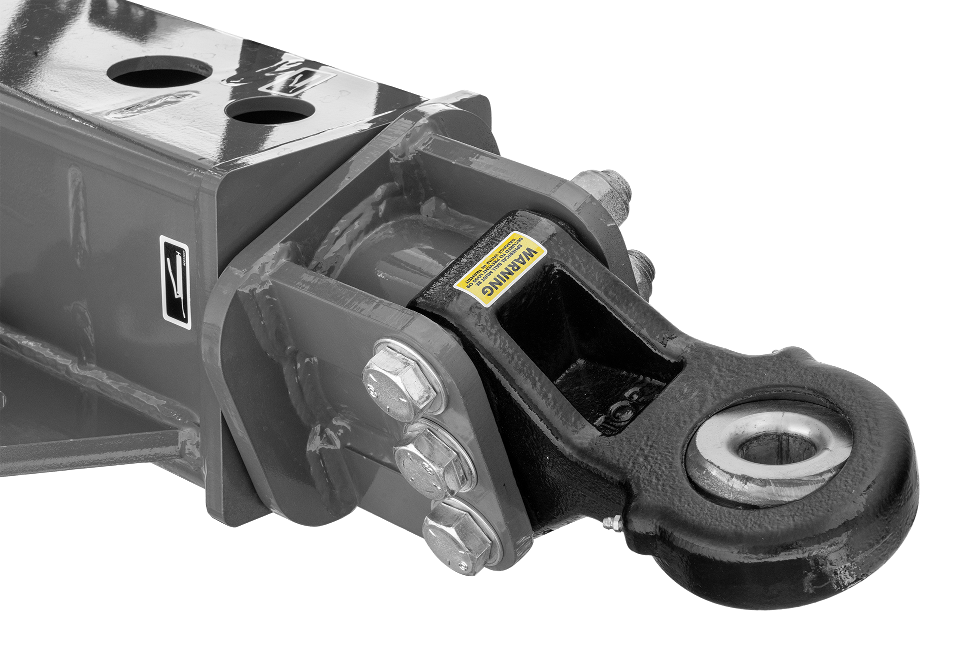 Close-up of a metal trailer hitch with a warning label and bolts, ready for attachment to a vehicle.