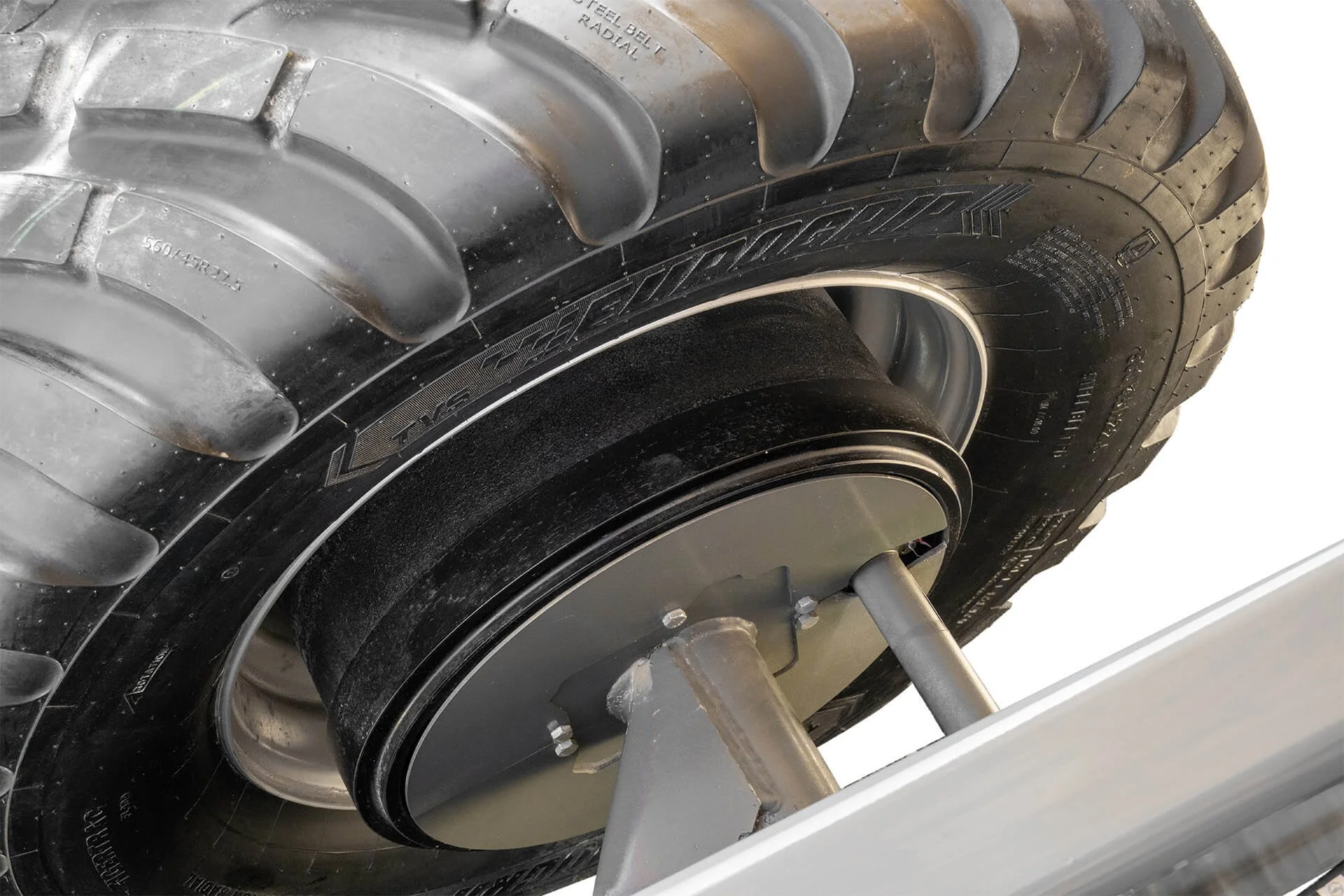 Close-up of a large industrial or truck tire mounted on a wheel, showing the tread pattern and sidewall details.
