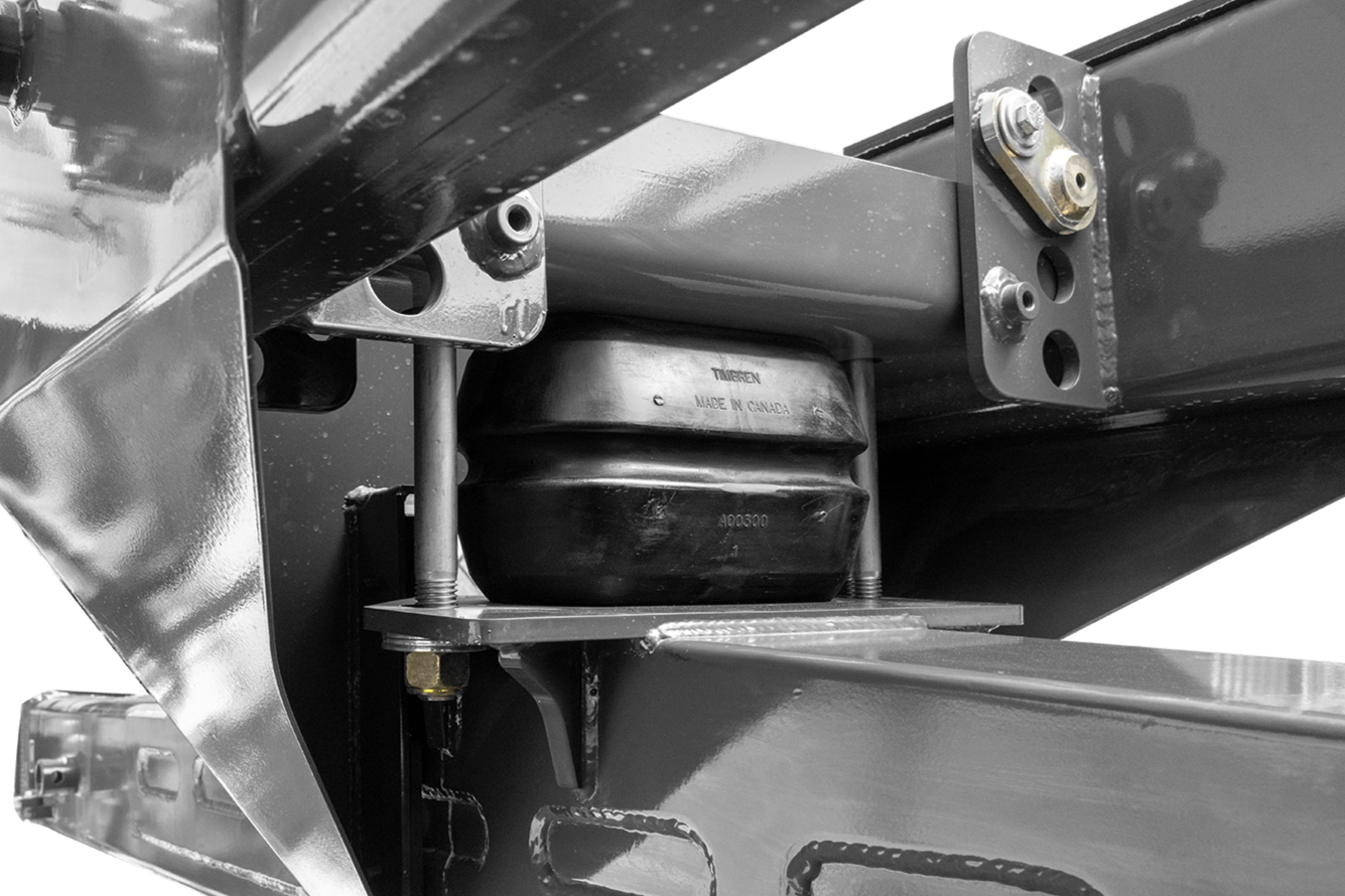 Close-up of a mechanical assembly with metal brackets, bolts, and a black rubber component labeled "TIGEREN MADE IN CANADA."