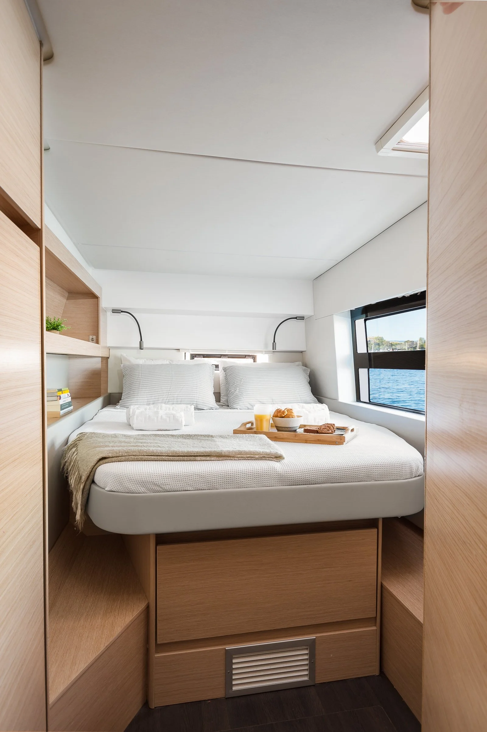 A cozy bedroom with a bed, breakfast tray, and view of water through a window. Hotels, Villas, Airbnb photography. Corfu, Greece.