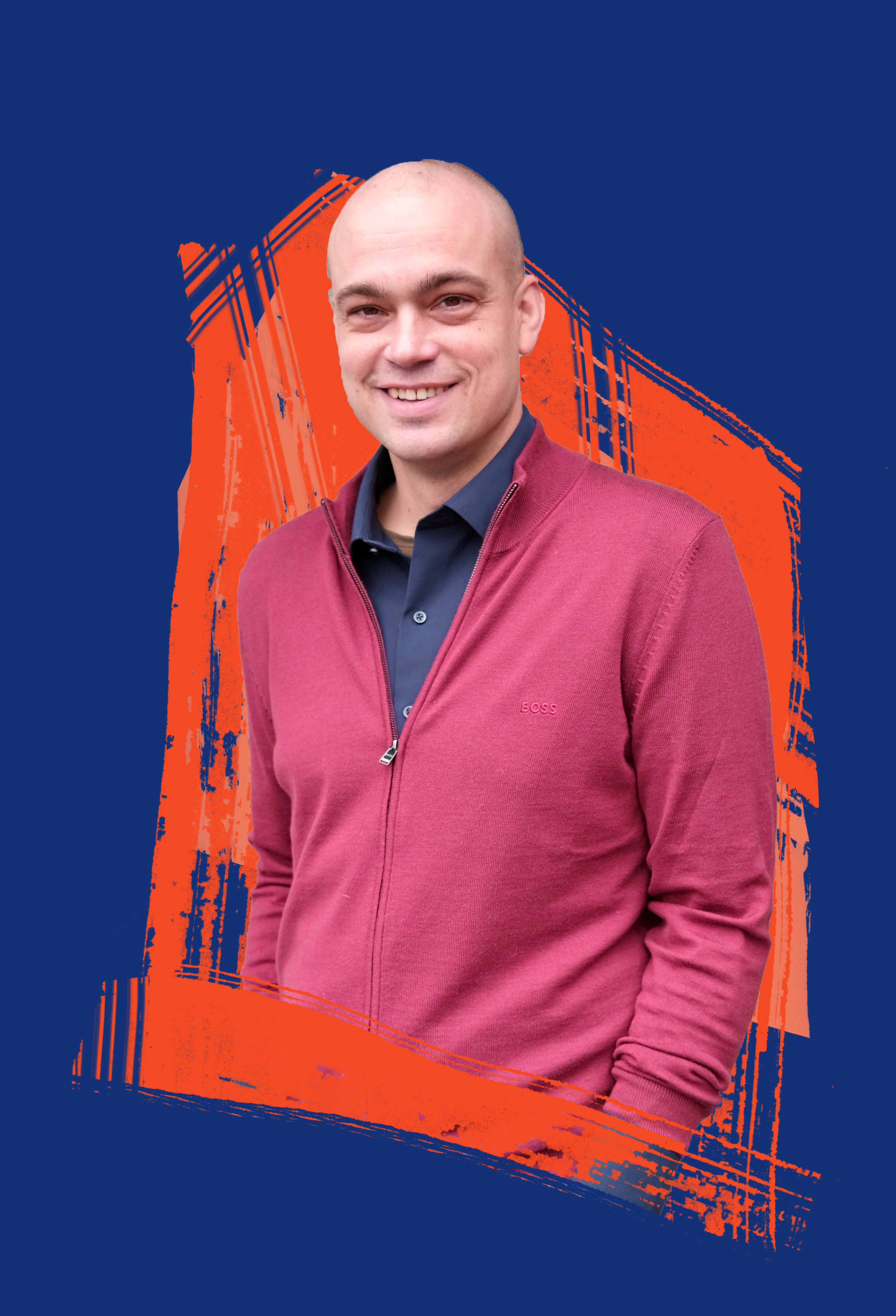 Noah Worcester, wearing a dark shirt and a red zip-up jacket, smiles while standing in front of a blue background with orange abstract brush strokes.