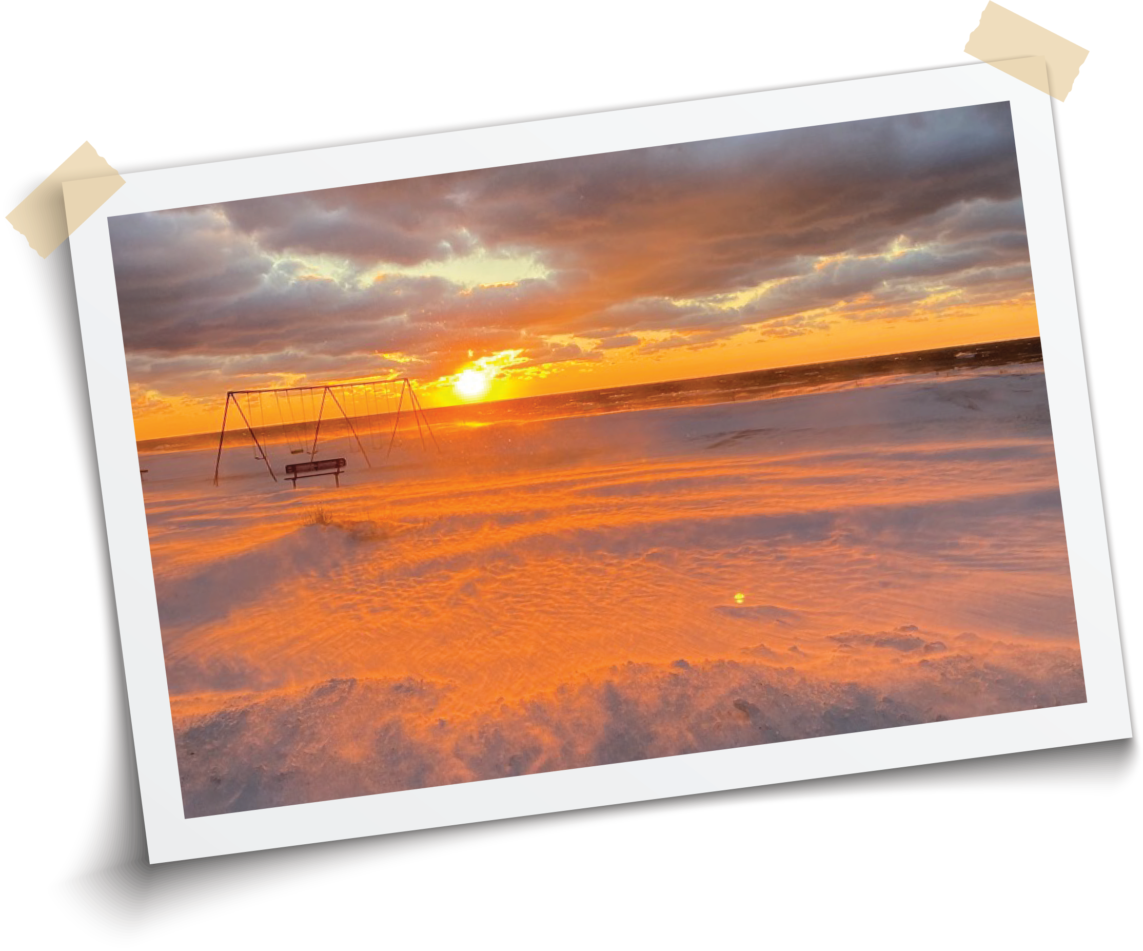 Sunset over a Lake Michigan beach with orange and purple sky, empty swings and a park bench in the sand.