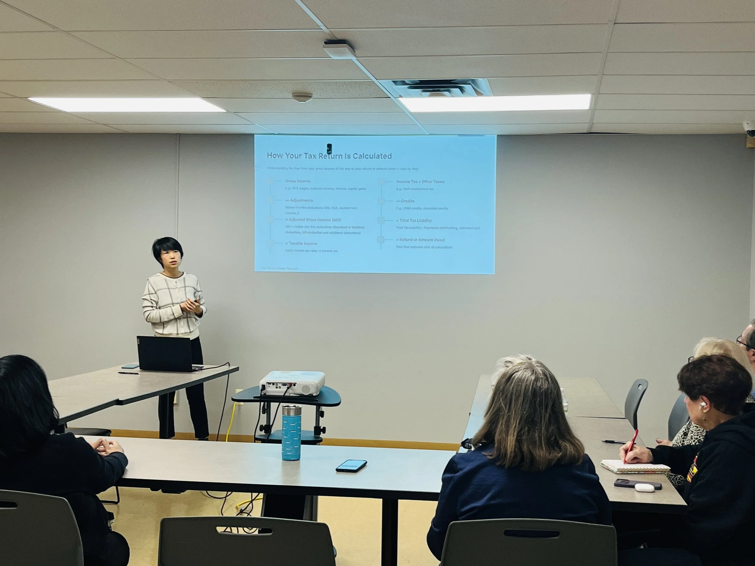 Sue Yuan presenting a tax workshop to a group of attendees.
