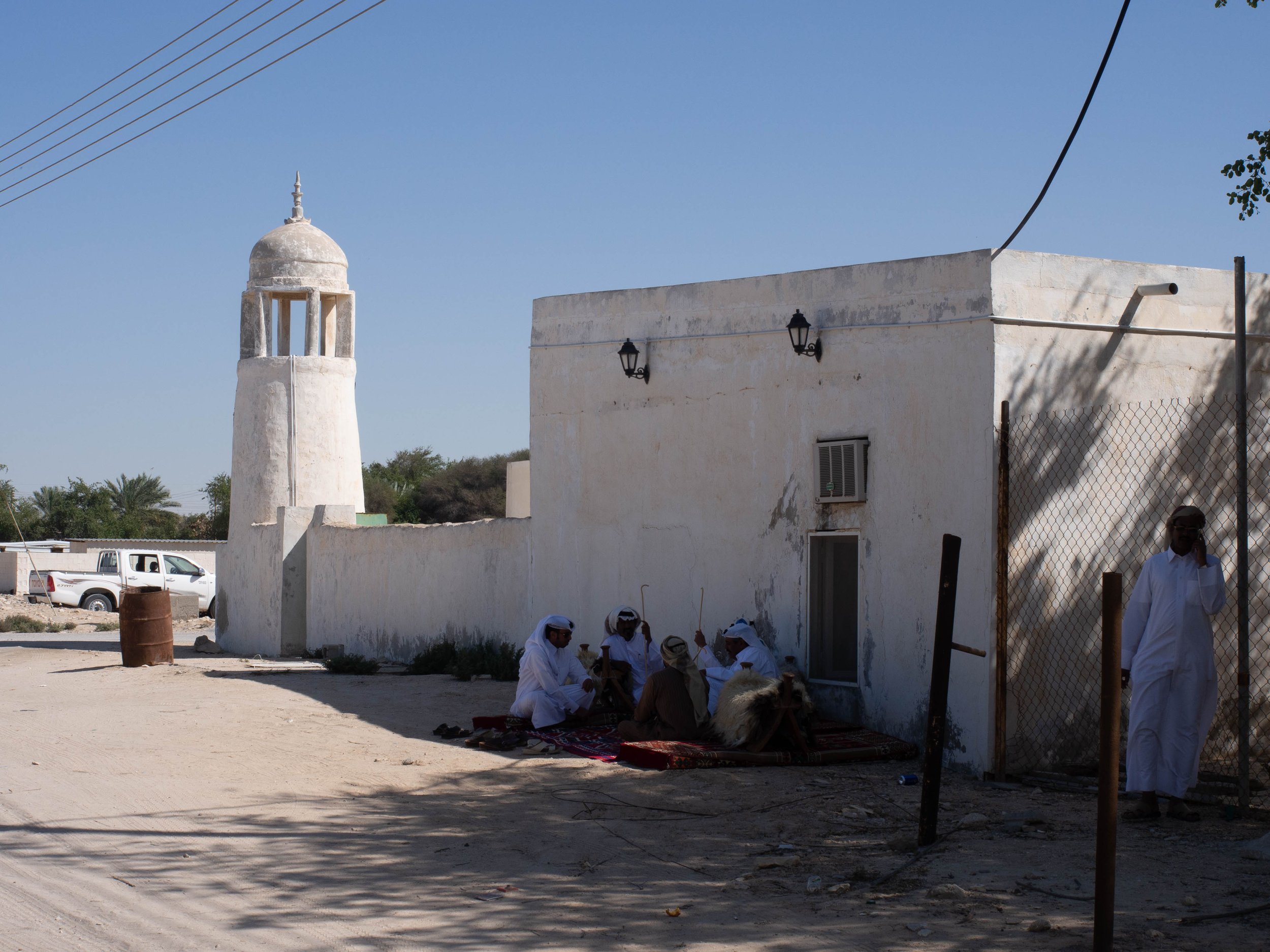 Men sharing dates and coffee outside an Old Mosques in the east cost of Qatar