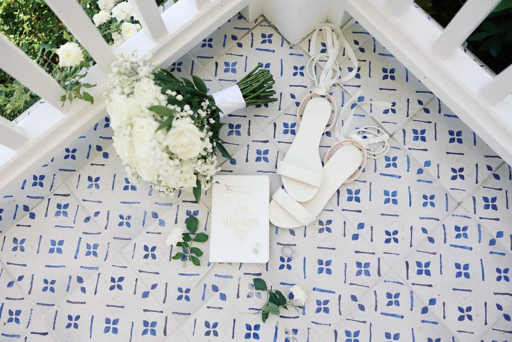 Wedding detail flat lay featuring bridal bouquet, shoes, and accessories at a romantic celebration planned by Always Eden Events.