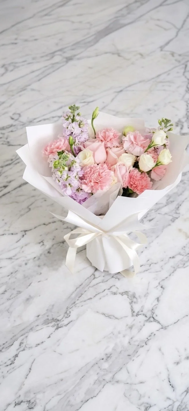 pink-carnation-rose-stock-lisianthus-white-wrapped-bouquet-marble.jpg