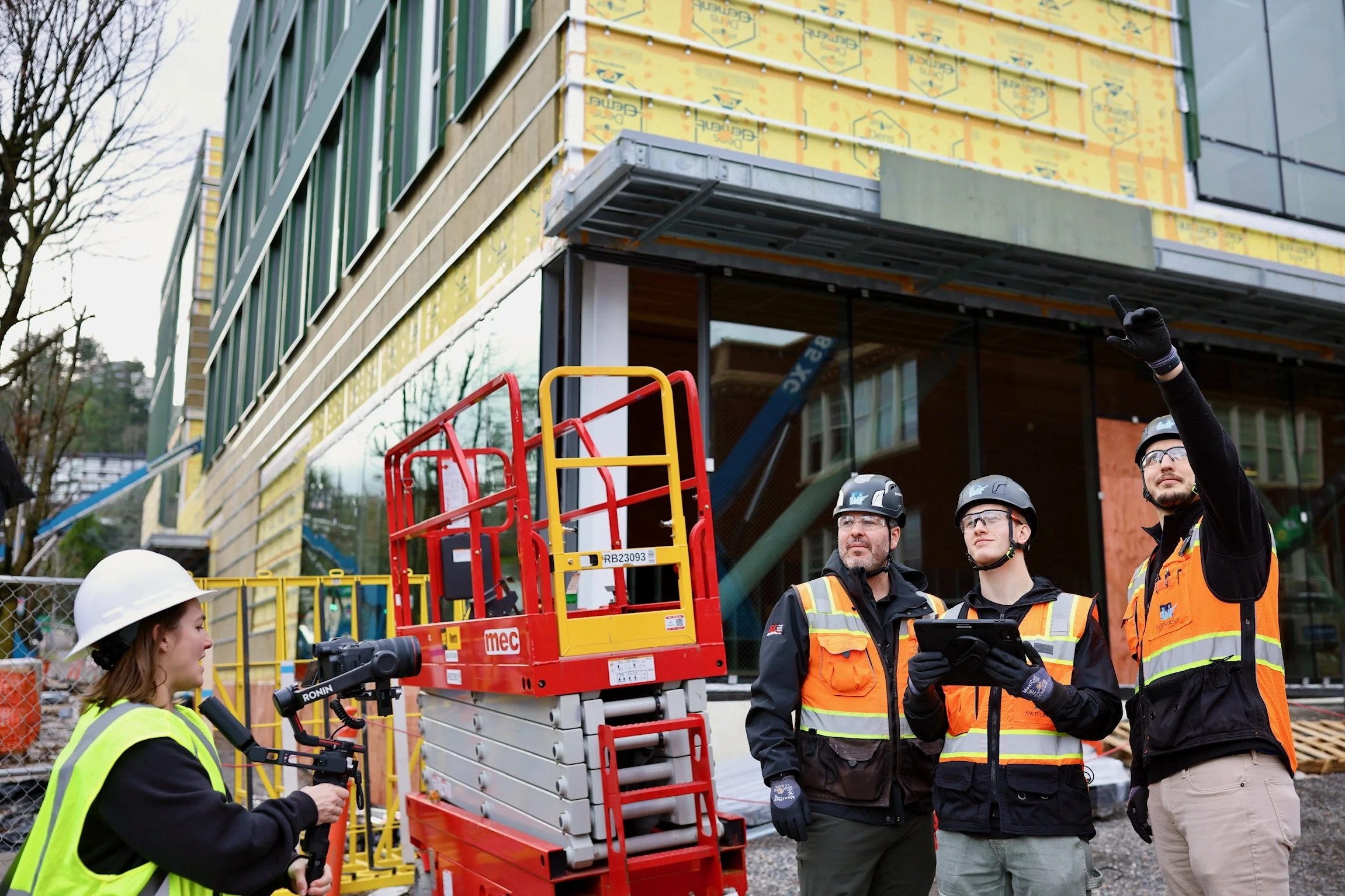 Construction workers at a building site inspecting plans and equipment.