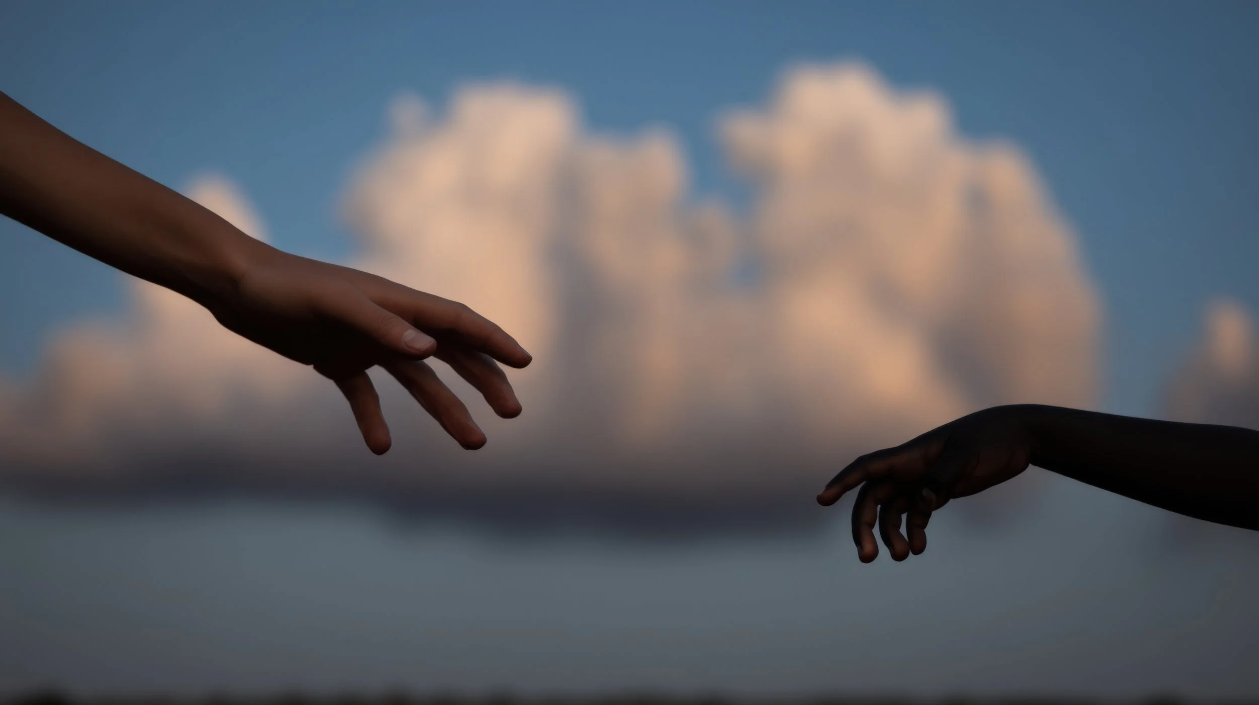 Two hands reaching towards each other against a sky with clouds.