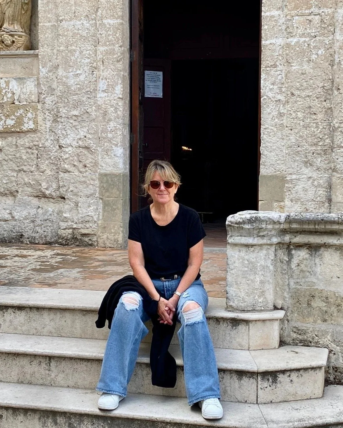 Jen in Puglia sitting on a doorstep