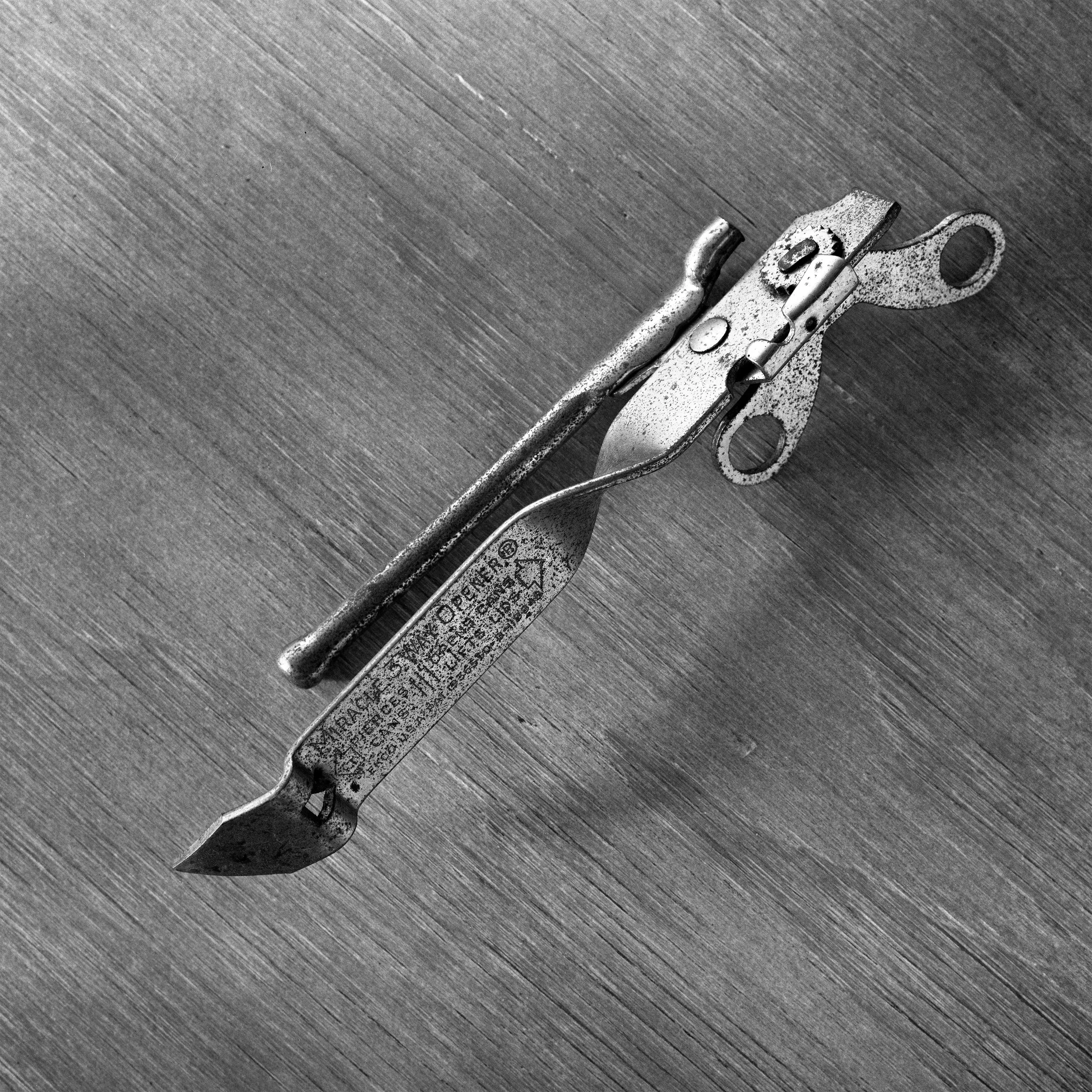 A metal mechanical part with a textured surface, bolts, and elongated holes, resting on a wooden surface.