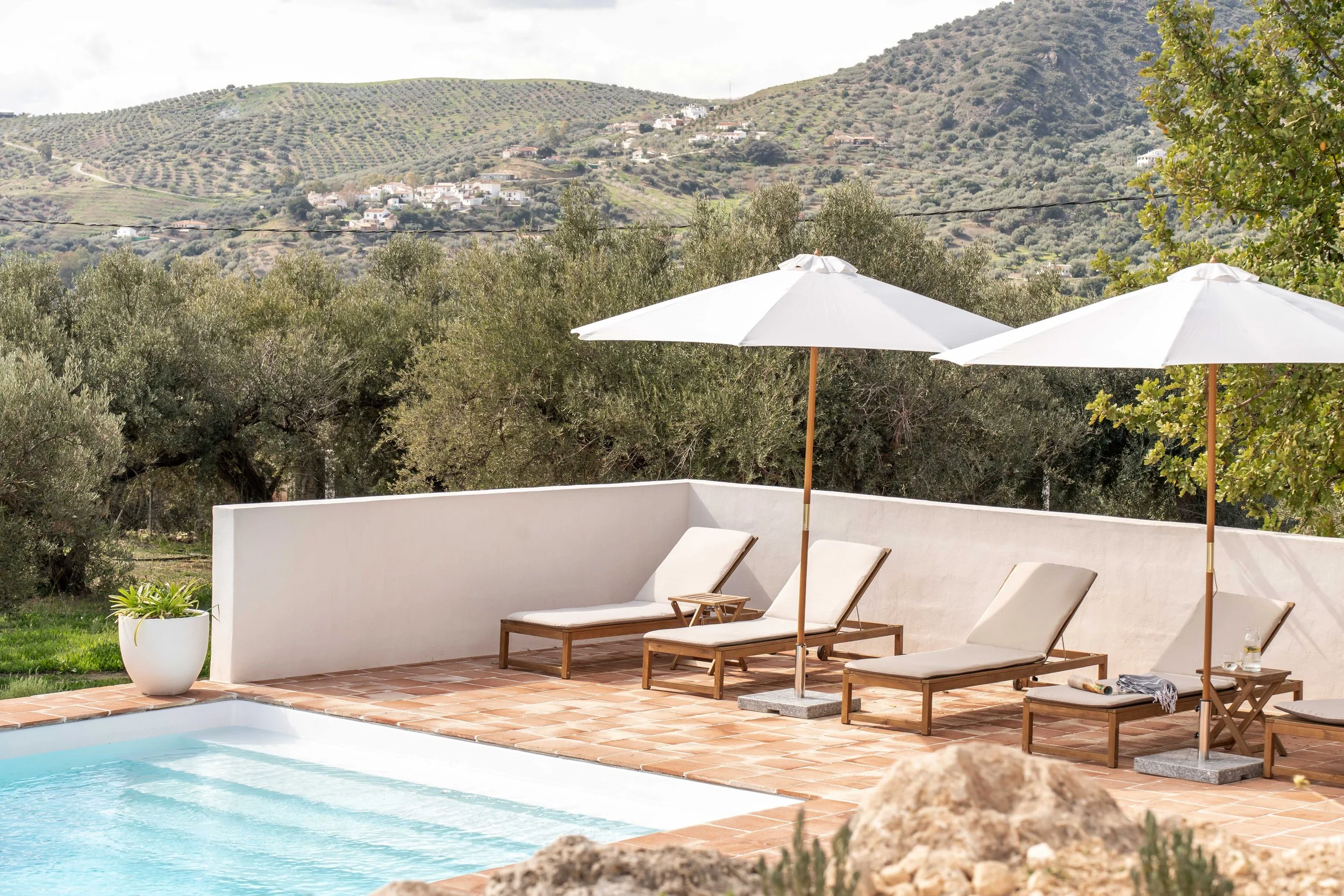 Zwembad met ligstoelen omgeven door bergen Andalusië