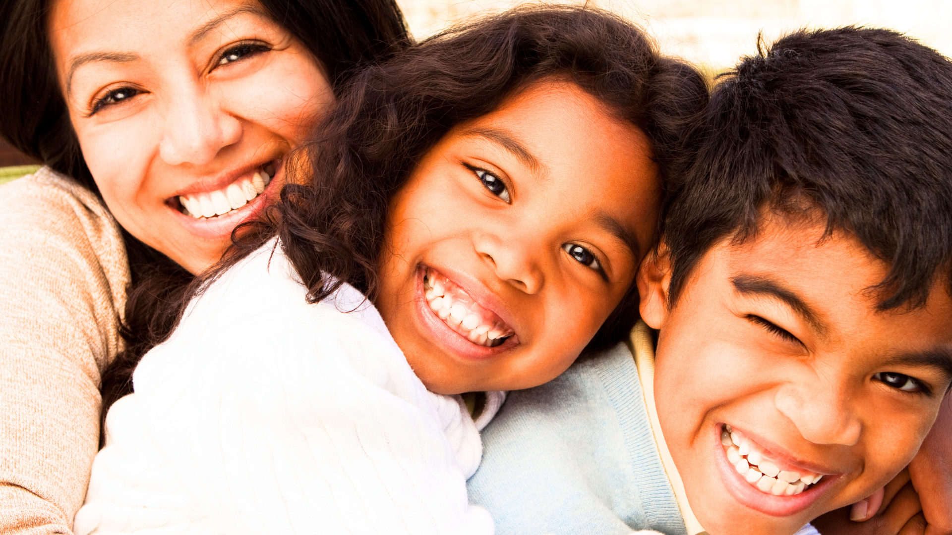 Close-up of a group of smiling people with diverse ethnic backgrounds, showing happiness and joy.