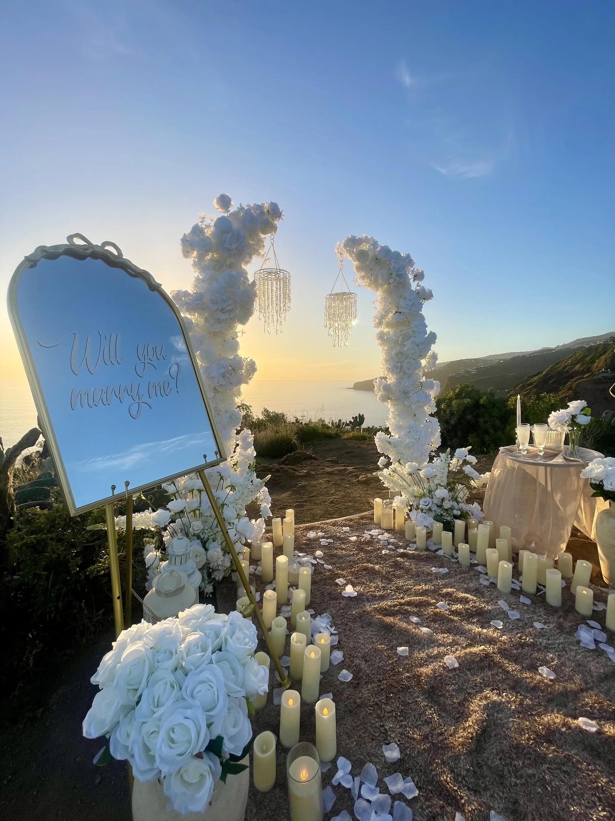 glam proposal setup madeira white flower arch and chandeliers