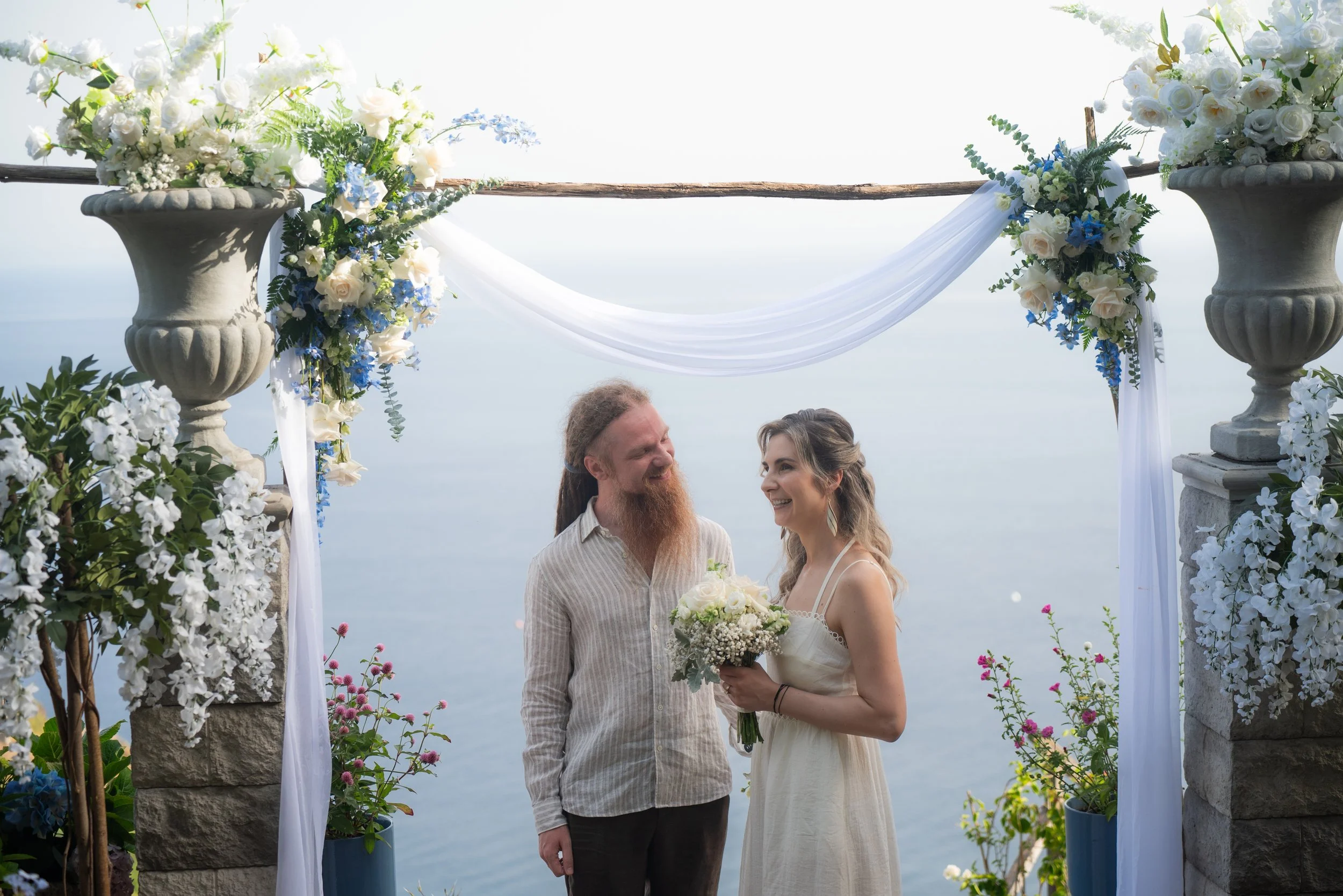 couple under wedding arch intimate elopement at the cliffside orchard madeira