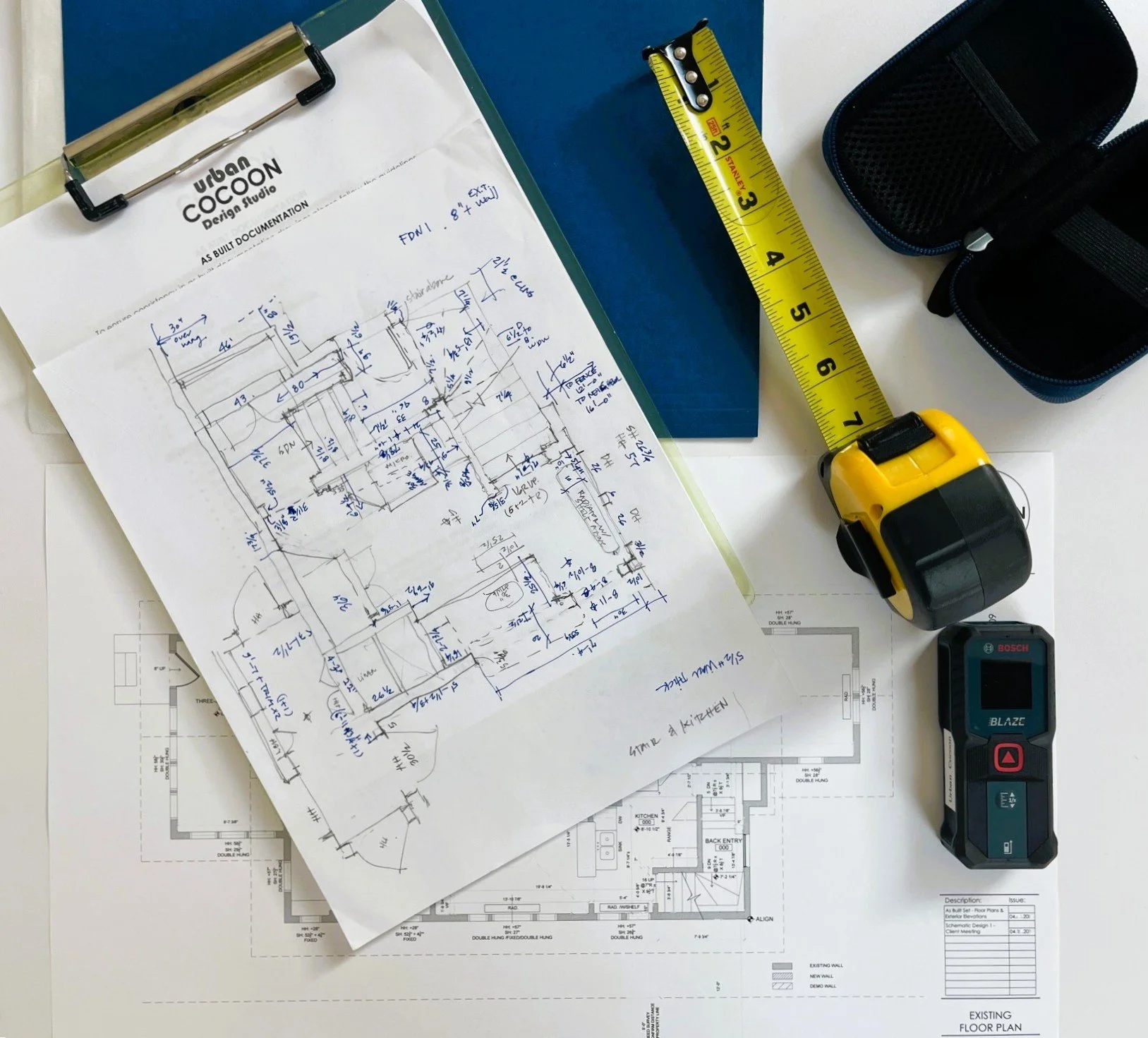 Architectural blueprints, sketches, and measuring tools for building design.