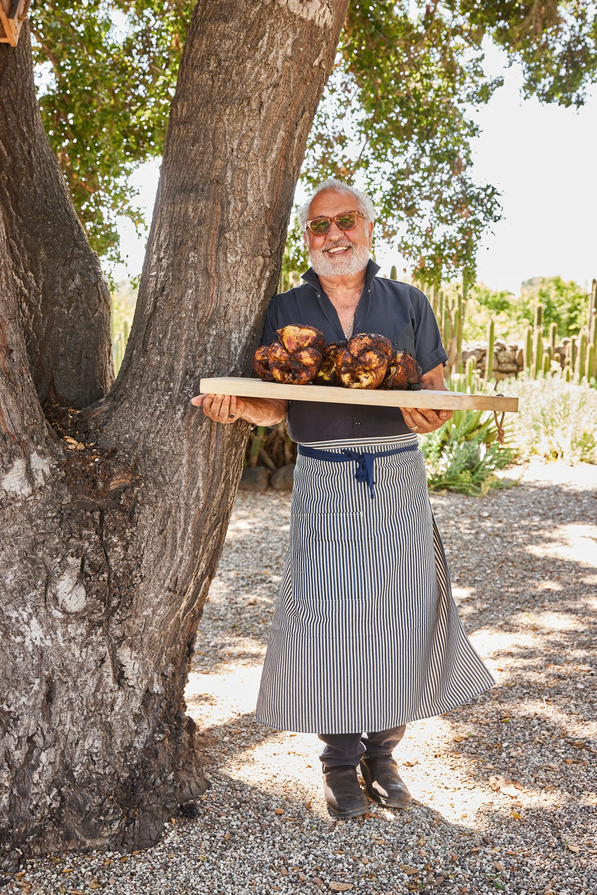 Chef Larry Nicola holding a tray of rotisserie chicken at an Ojai Rôtie catering event