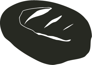 Close-up of a loaf of bread with three slashes on the top.