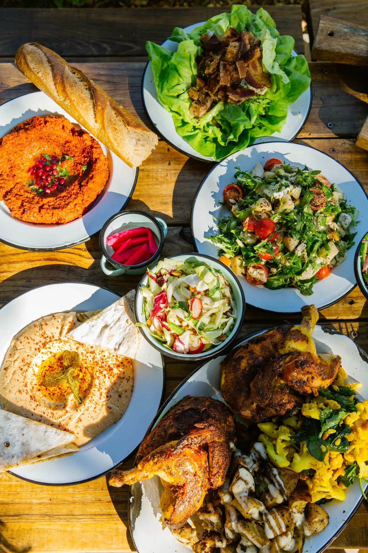 Ojai Rôtie catering spread — rotisserie chicken, hummus, tabouli, and Lebanese-French sides