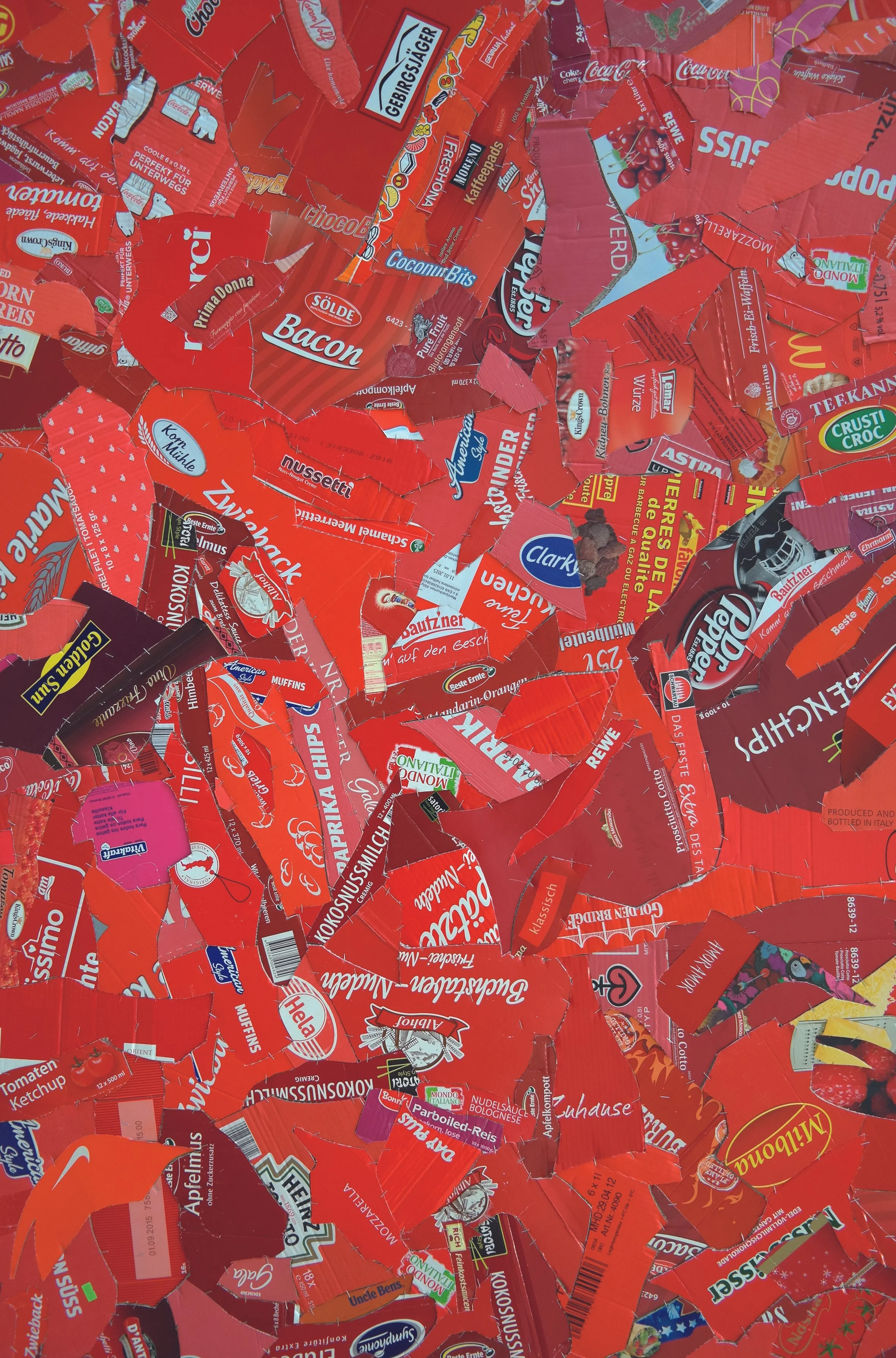 Collage of torn red food packaging labels and advertisements.