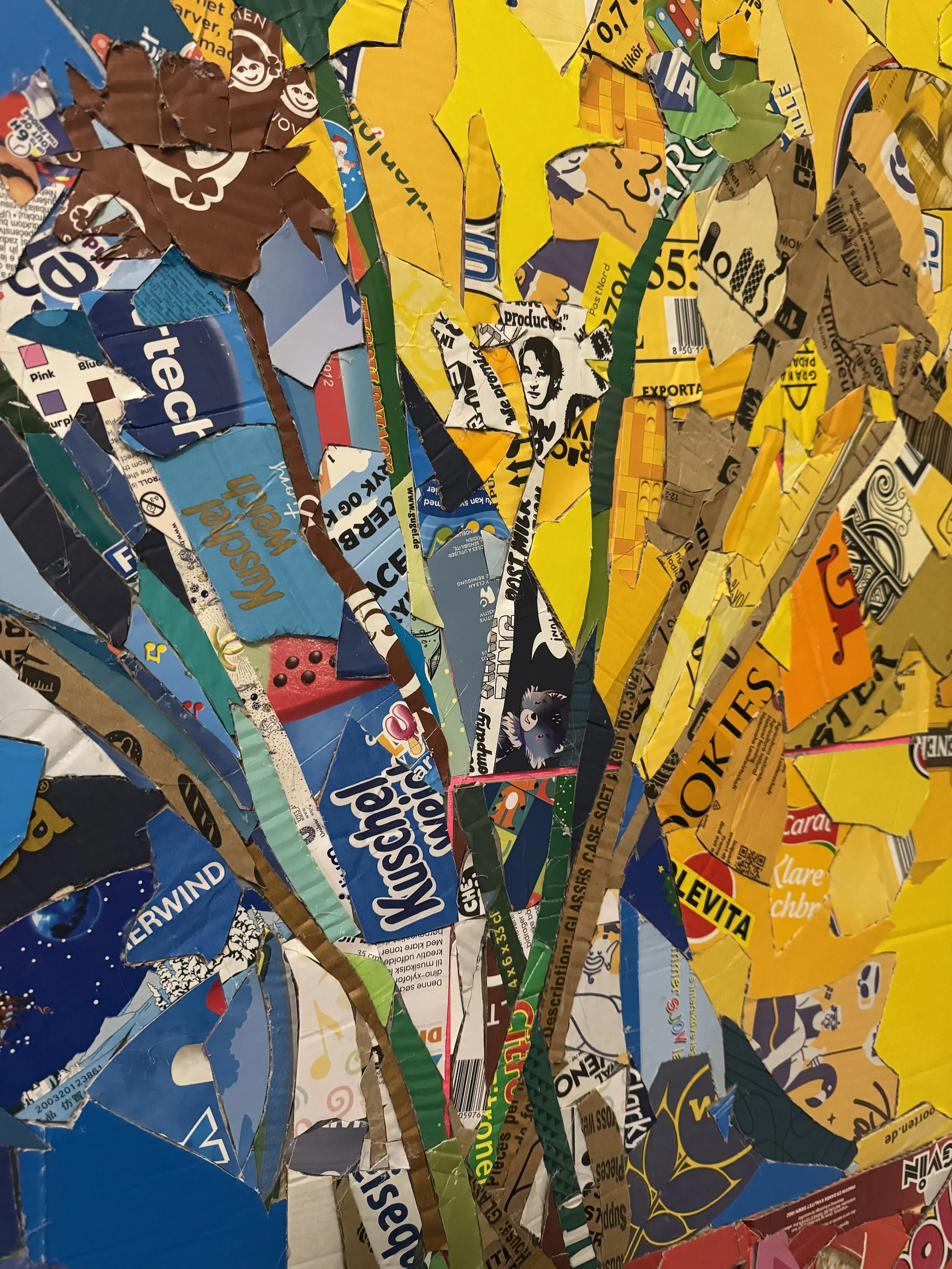 A collage of torn magazine and packaging paper pieces layered to create an abstract image.