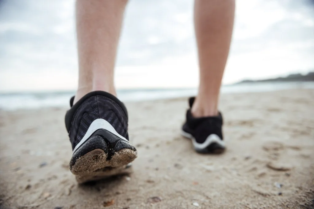 woman in walking shoes on a beach