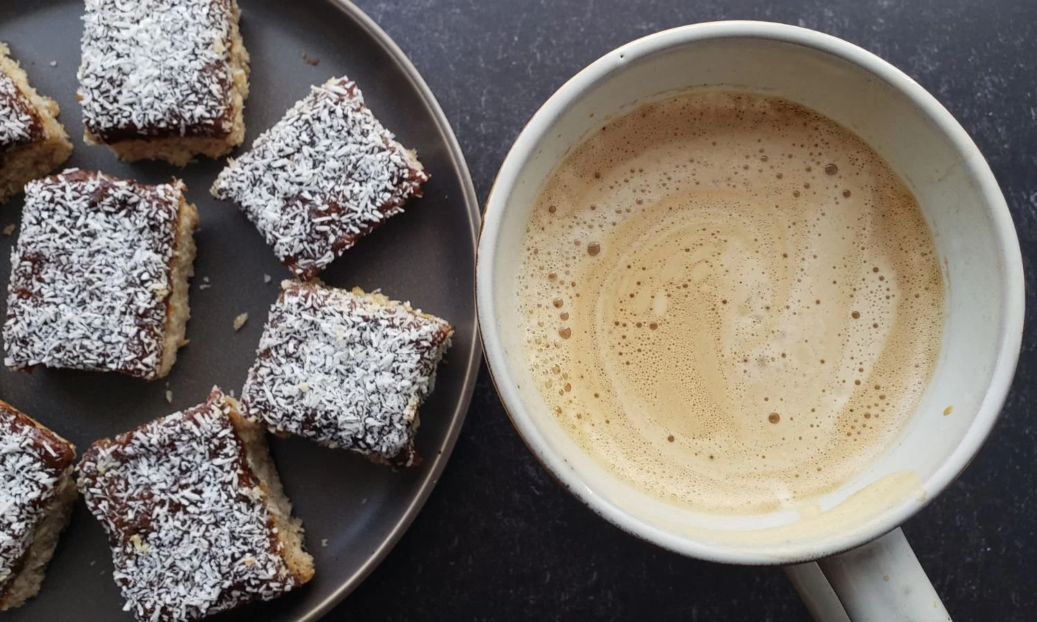 cut pieces of Apricot and Plum Coconut Bars with mug of coffee