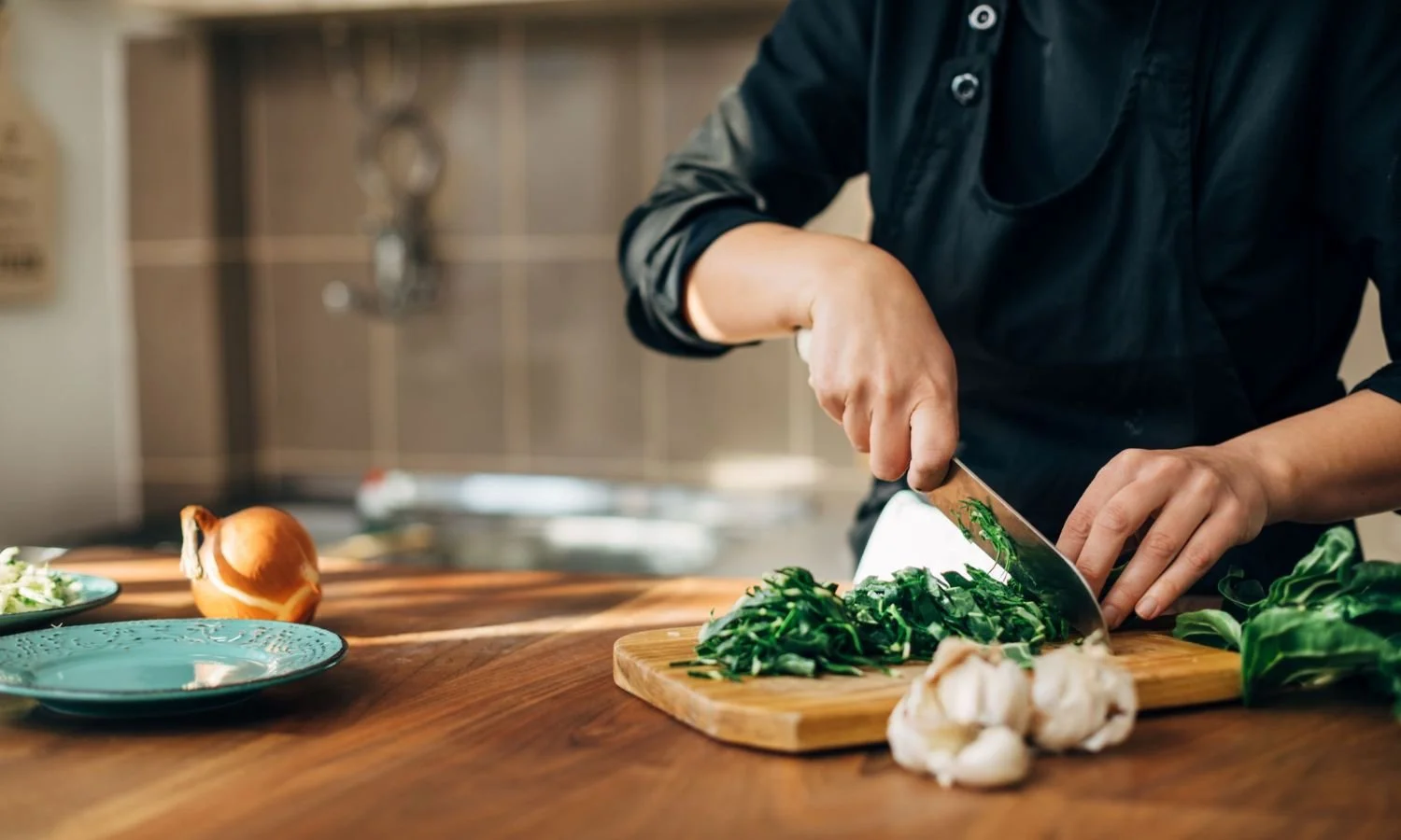a chef in the kitchen cutting herbs