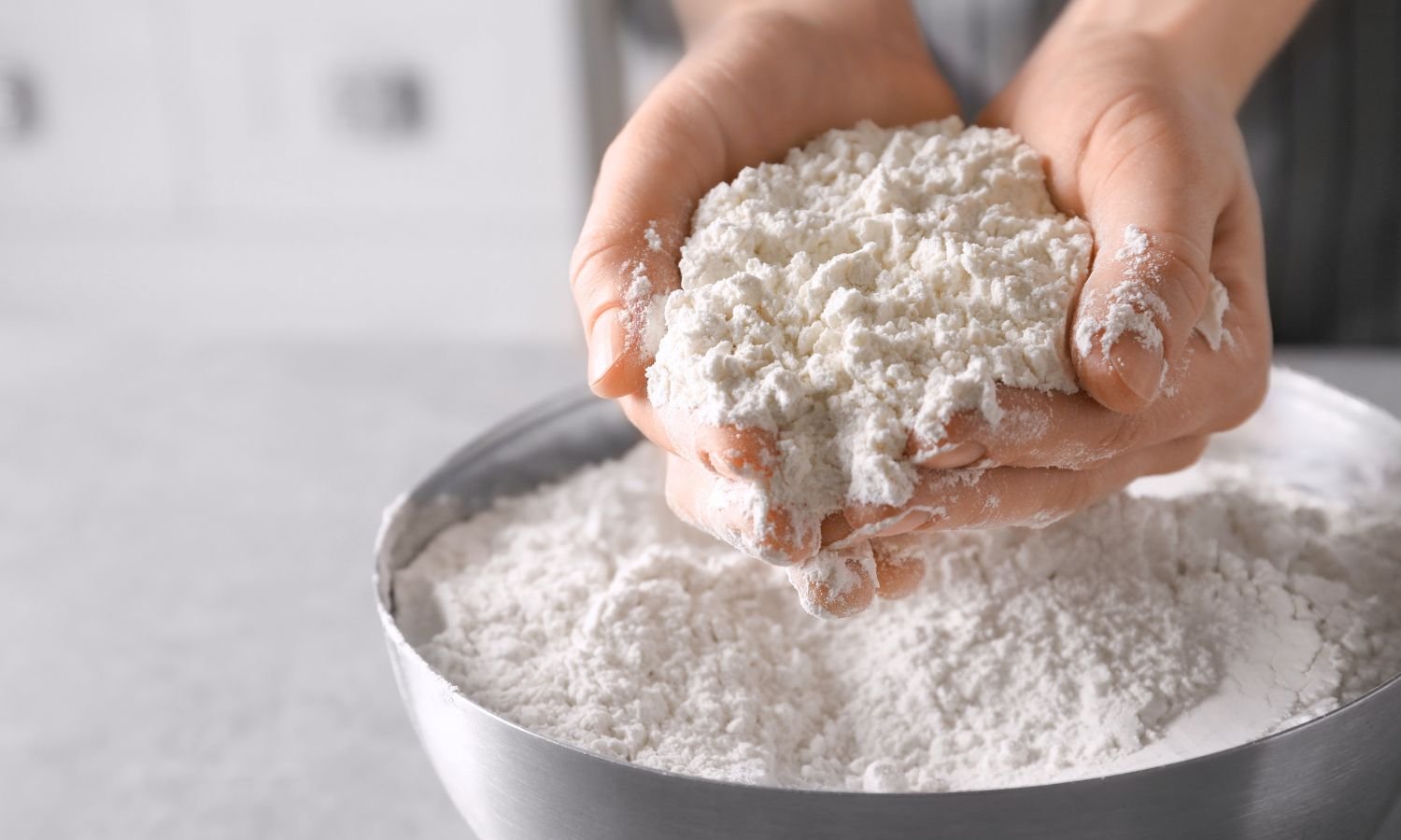 hands holding gluten free flour over bowl