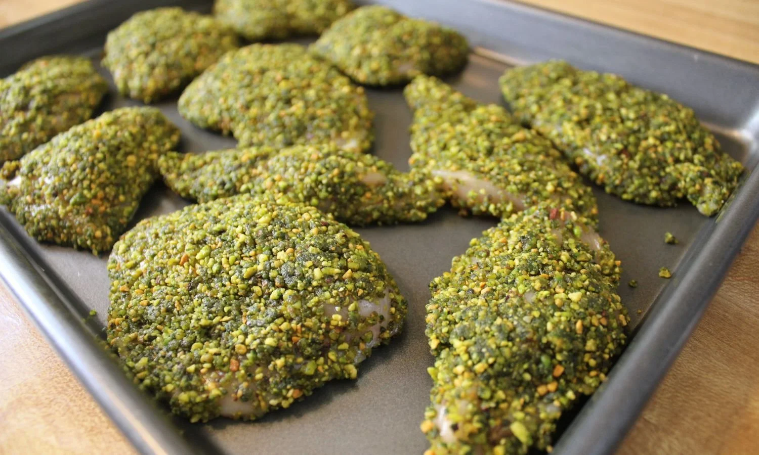 pistachio crusted chicken on baking sheet