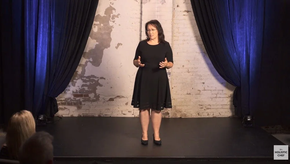 The Proof Talk Andrea Sprague standing on stage