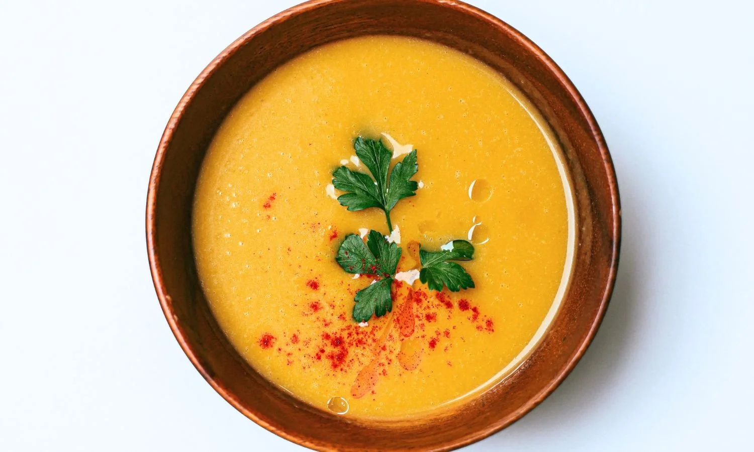 red lentil soup in bowl with garnish
