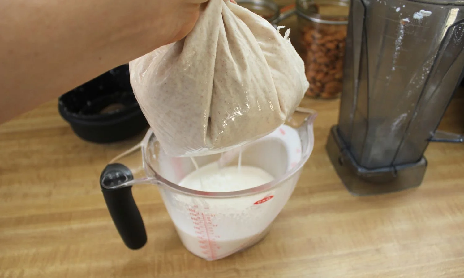straining nut milk through a mesh nut bag