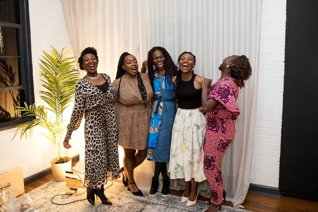 Laurie’s customers, Mariana and Carmen holding hands on a green lawn on their wedding day.
