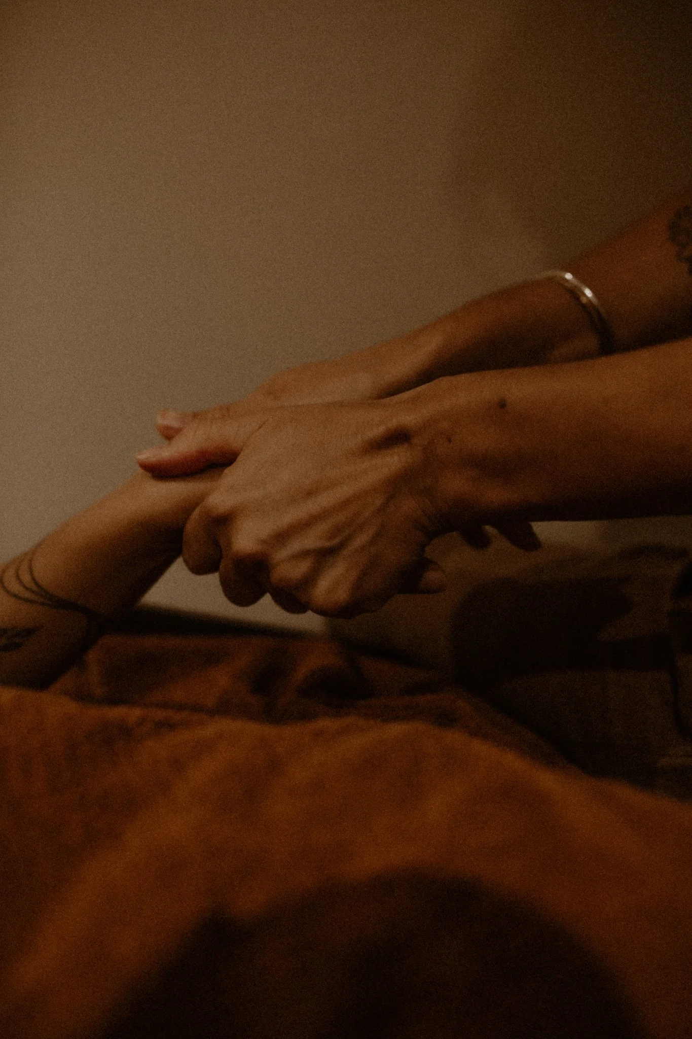 Close‑up of practitioner holding a client’s hand during a Flow Therapy Byron Bay session, symbolising presence, grounding, and gentle holistic care.