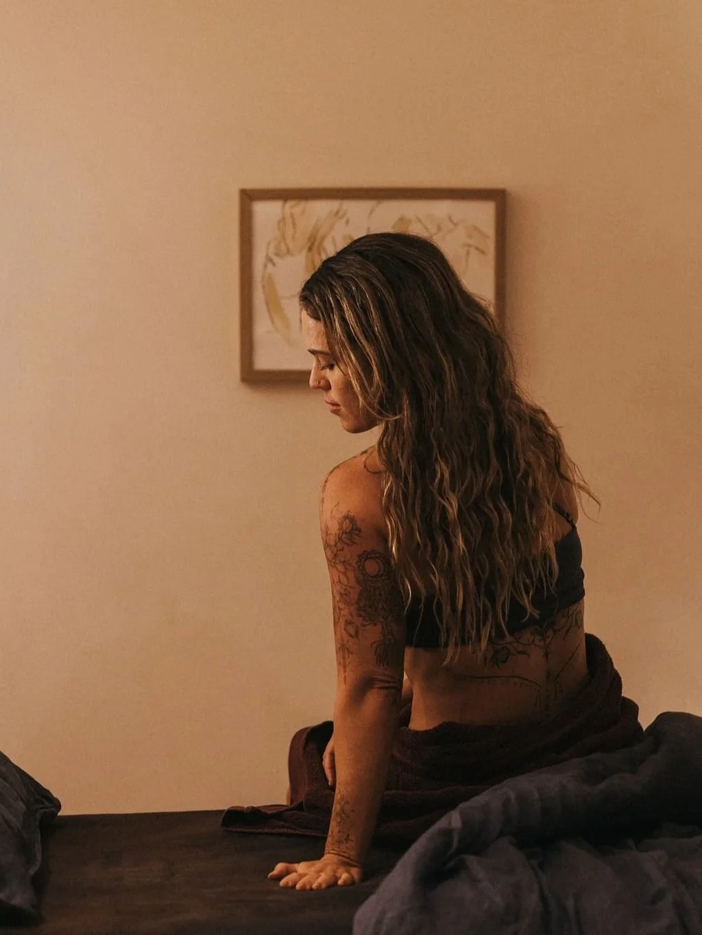 Female with tattoos sitting on treatment bed