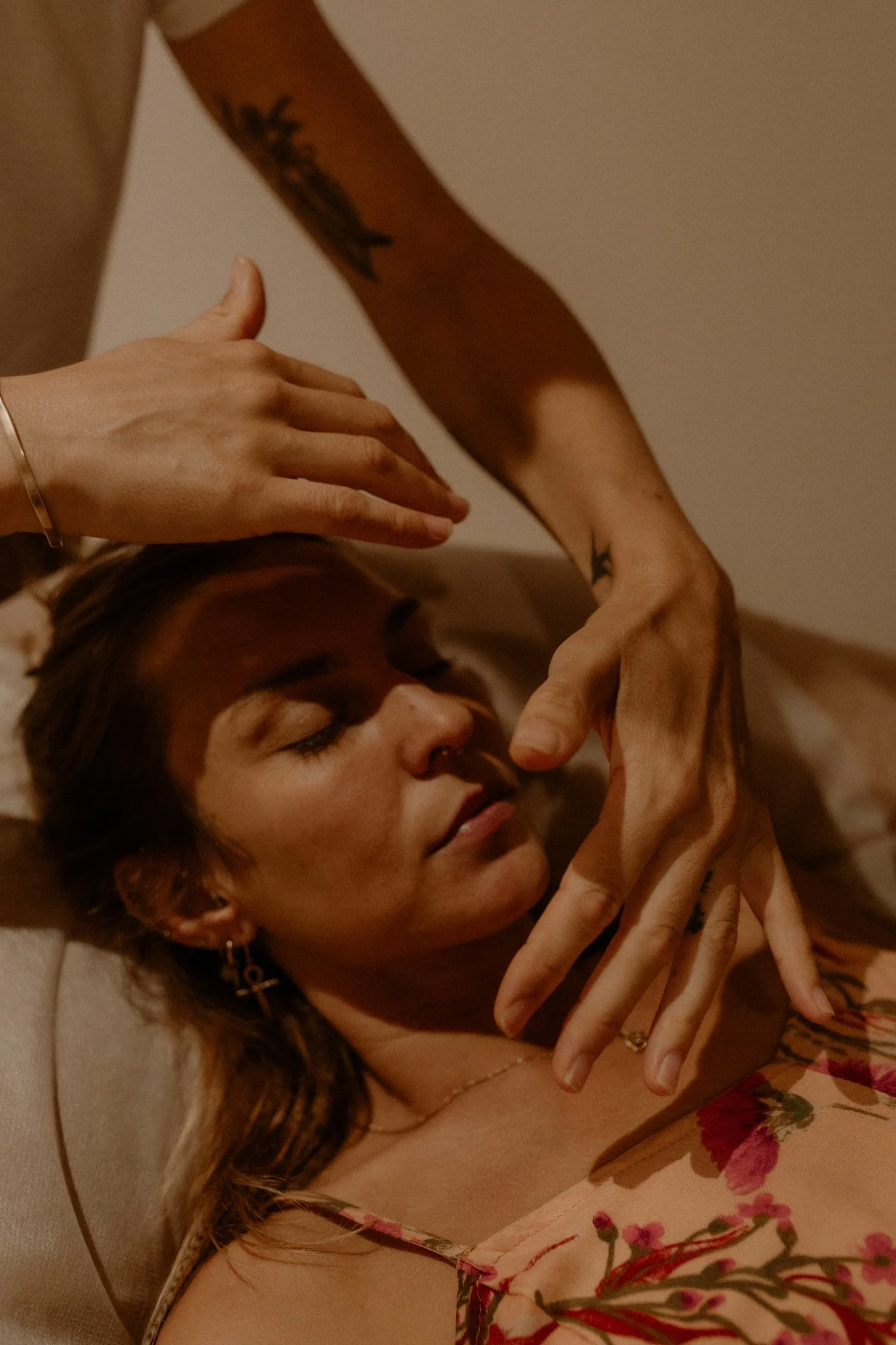 Close‑up of practitioner and client hands during a Flow Therapy Byron Bay treatment, capturing connection, safety, and gentle holistic care.