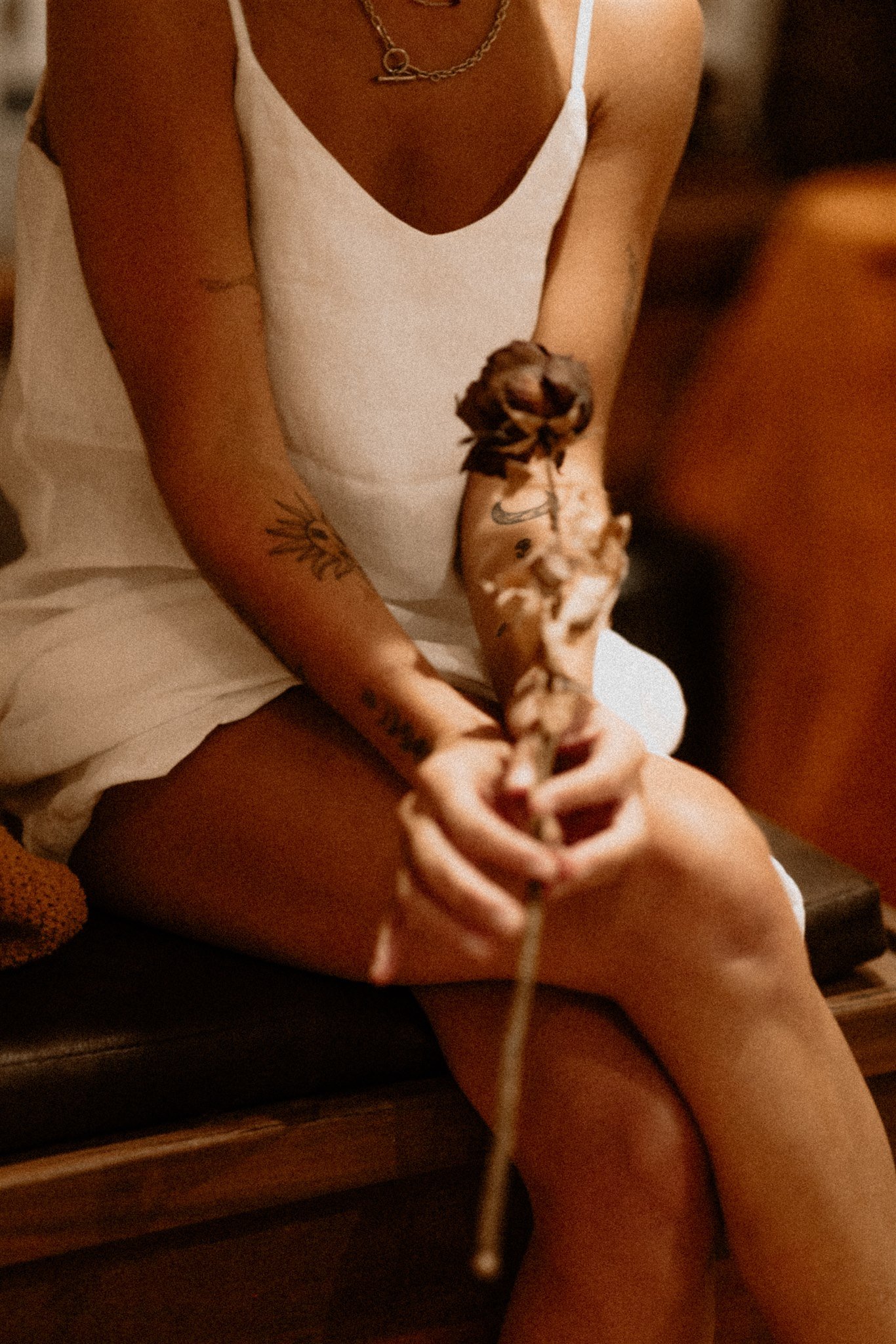 Hands holding a bundle of dried herbs and rose during naturopathic consultation. Artemis Apotheca