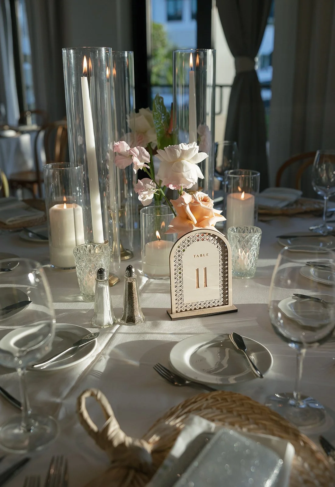 Elegant dining table set with candles, flowers, and glassware for a special event.