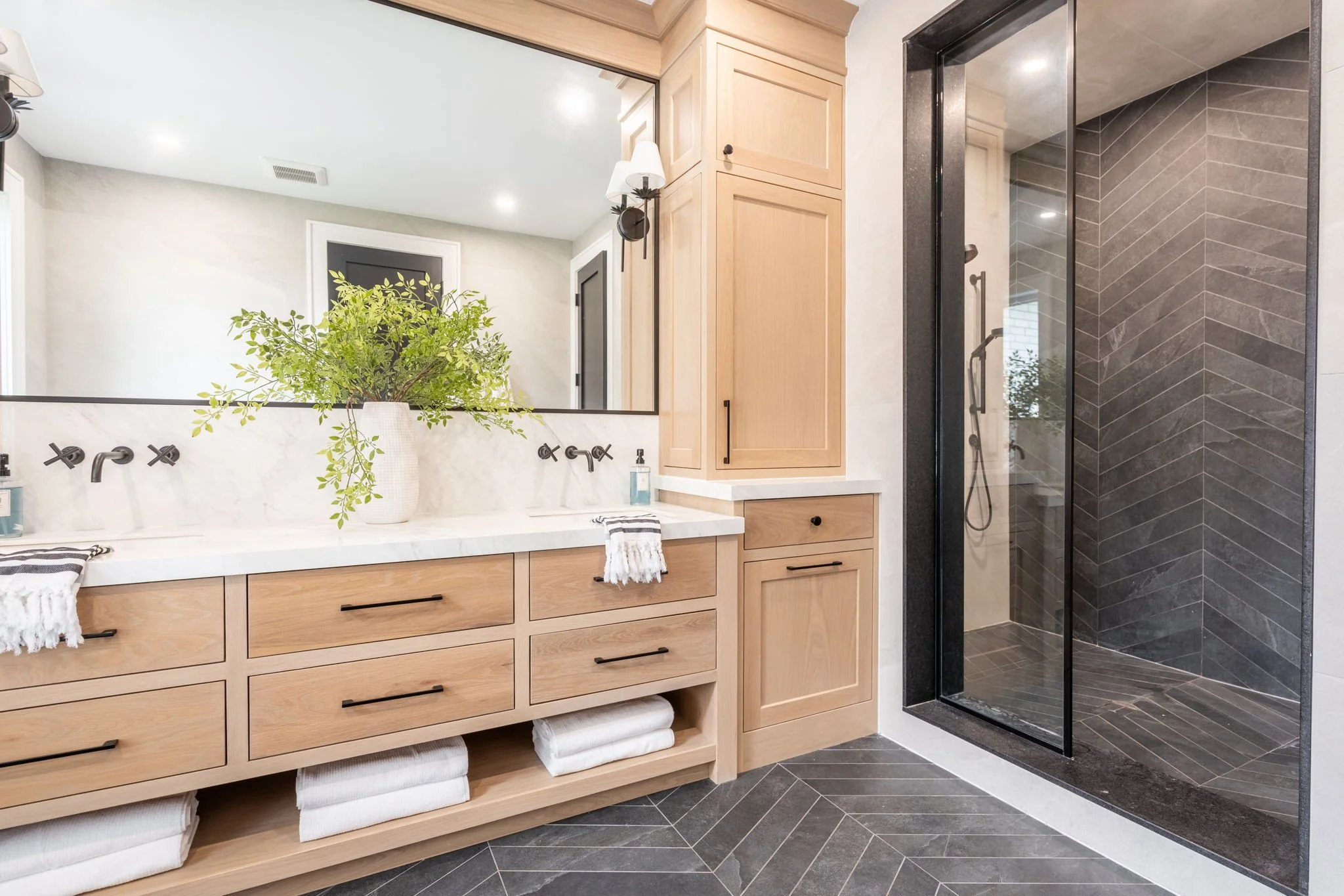 Bathroom with custom wood vanity and herringbone tile flooring interior design in Toronto Ontario by JT & Co Interiors