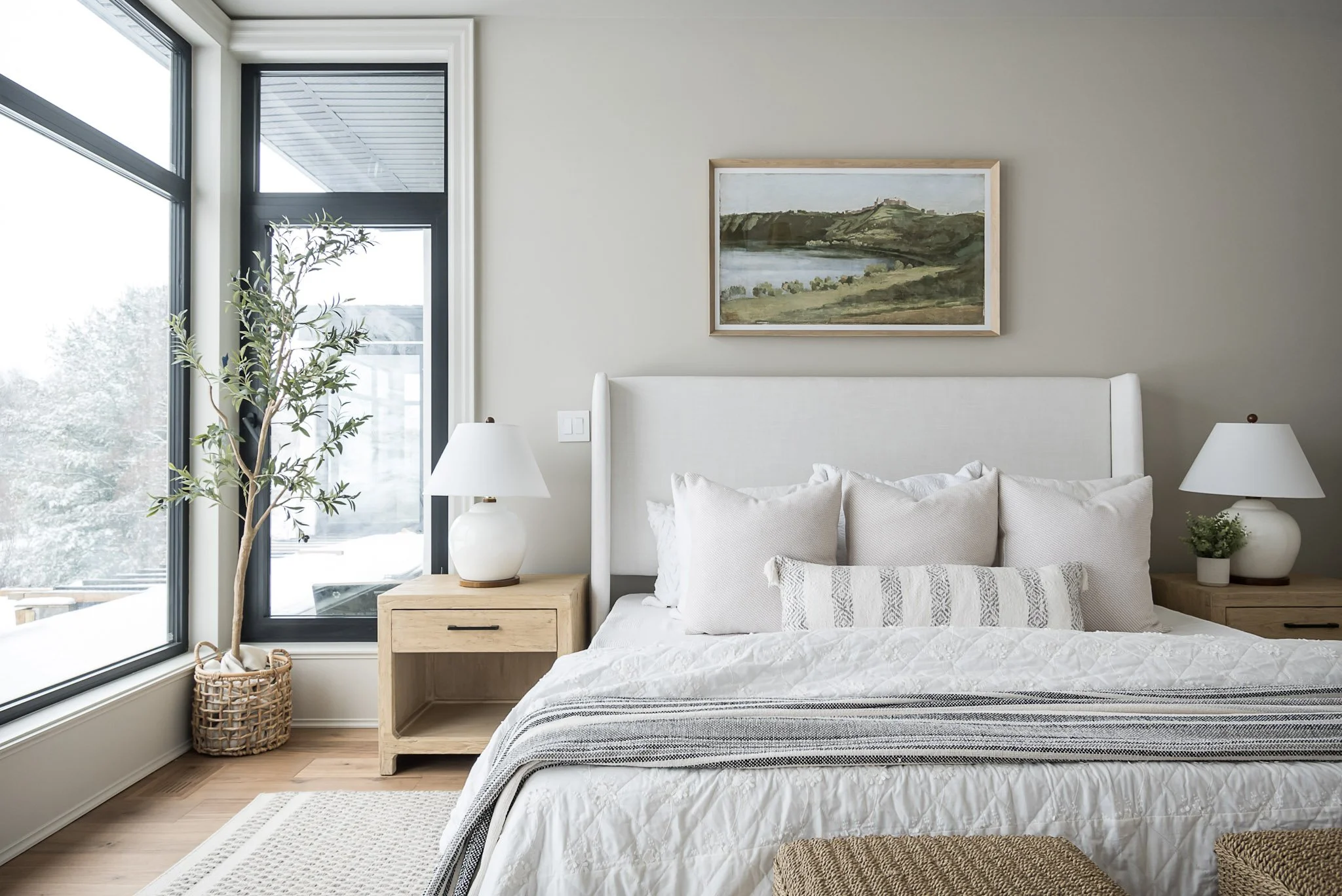 Primary bedroom with neutral bedding and large window interior design in Oakville Ontario by JT & Co Interiors