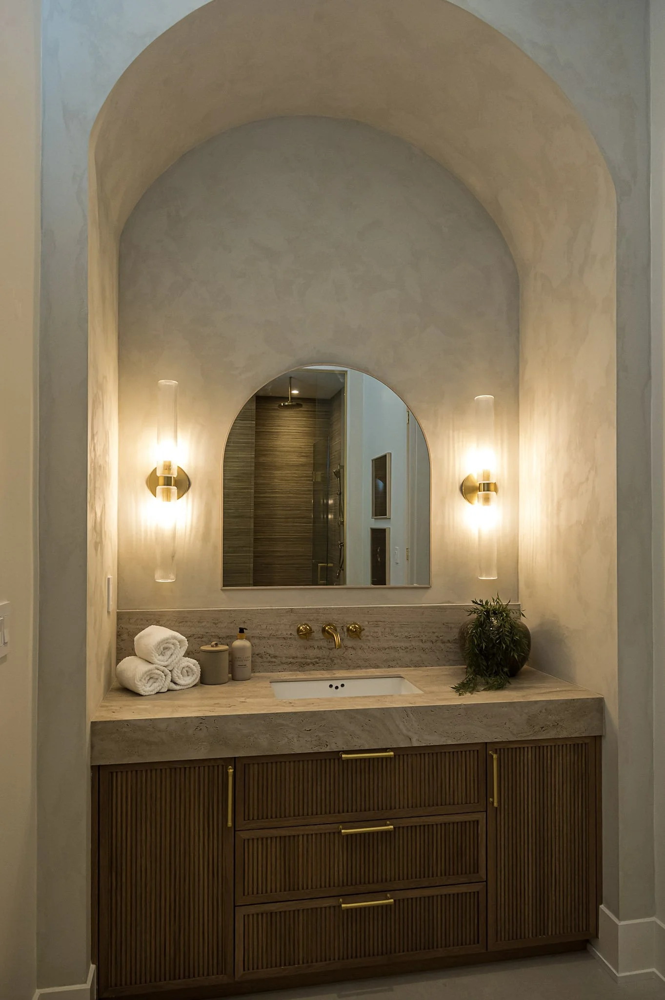 Bathroom with arched niche and fluted wood vanity interior design in Toronto Ontario by JT & Co Interiors